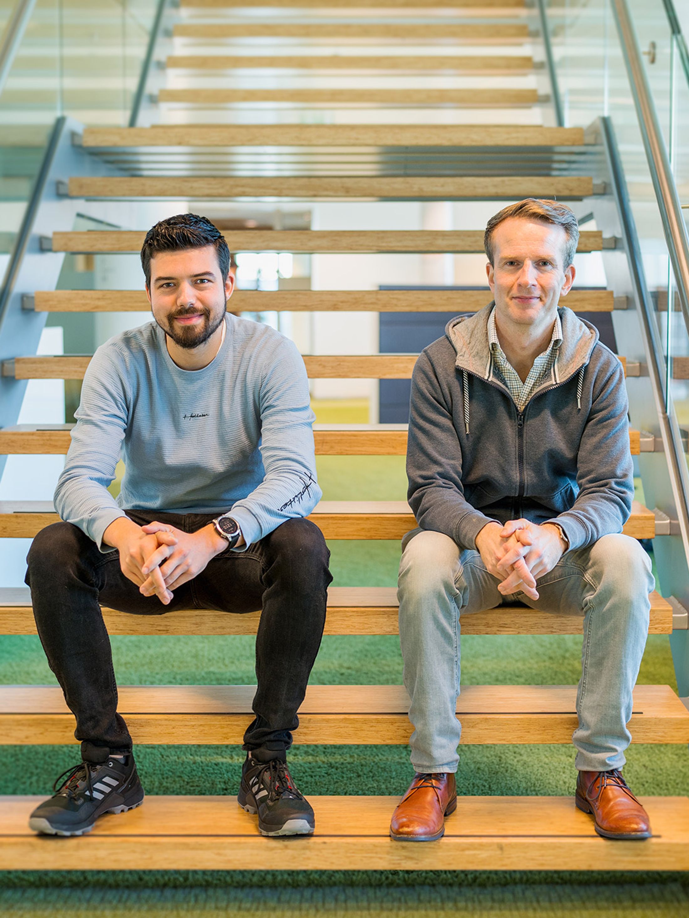 Luc en Neal sitting on the stairs in the office