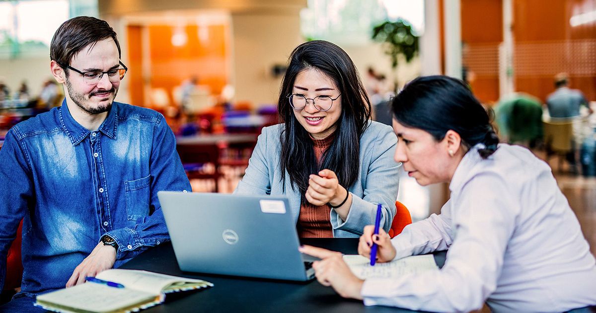 Jonge professionals in een open kantoor ruimte die aan het praten zijn met elkaar