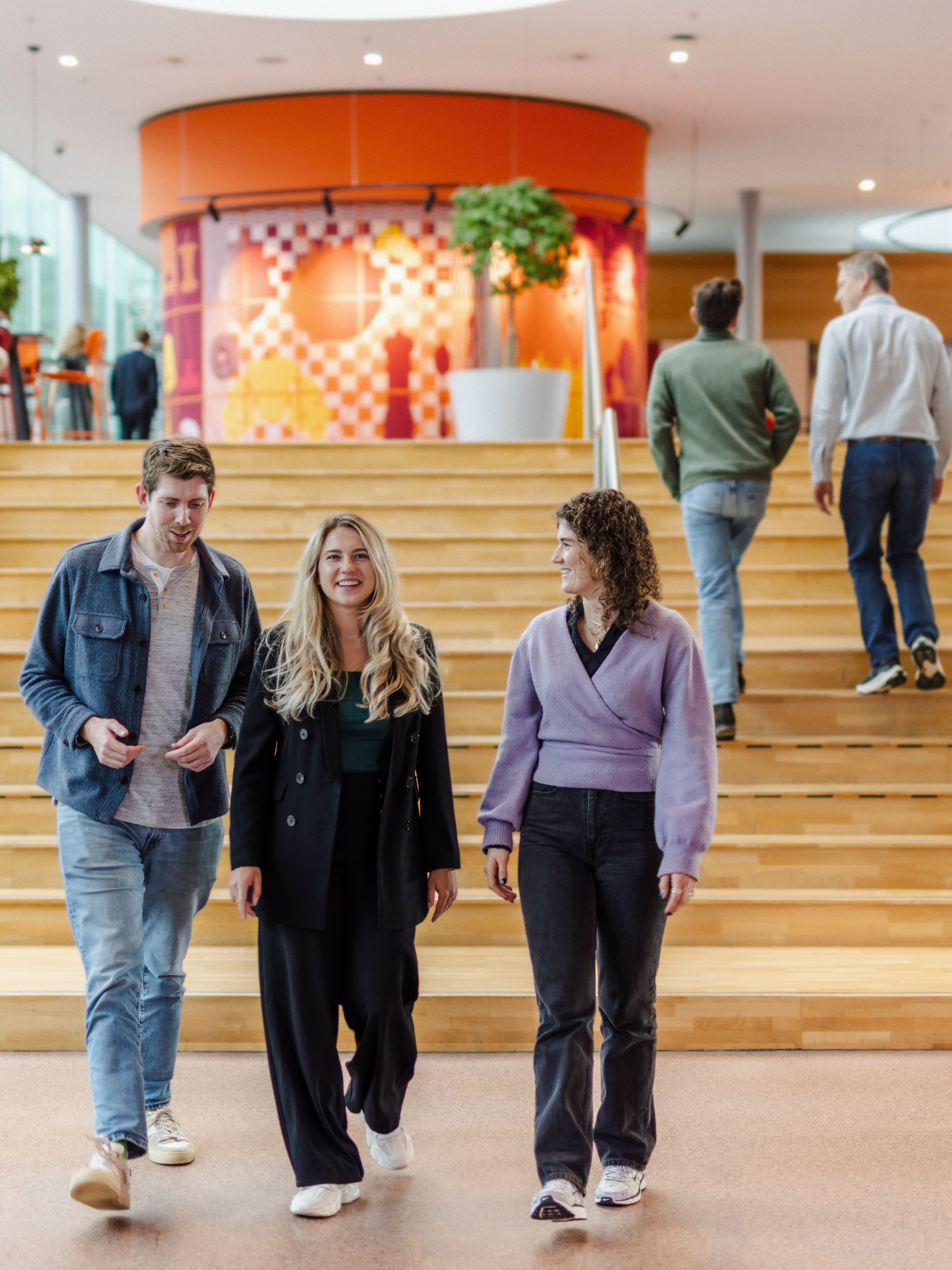 Three colleagues walking down the office
