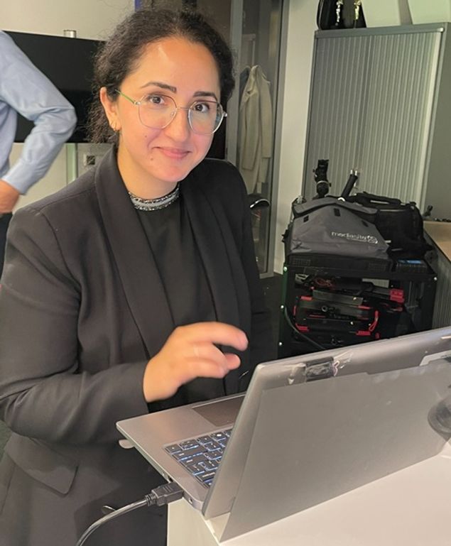 Foto van schrijfster van het artikel Hila lachend achter laptop