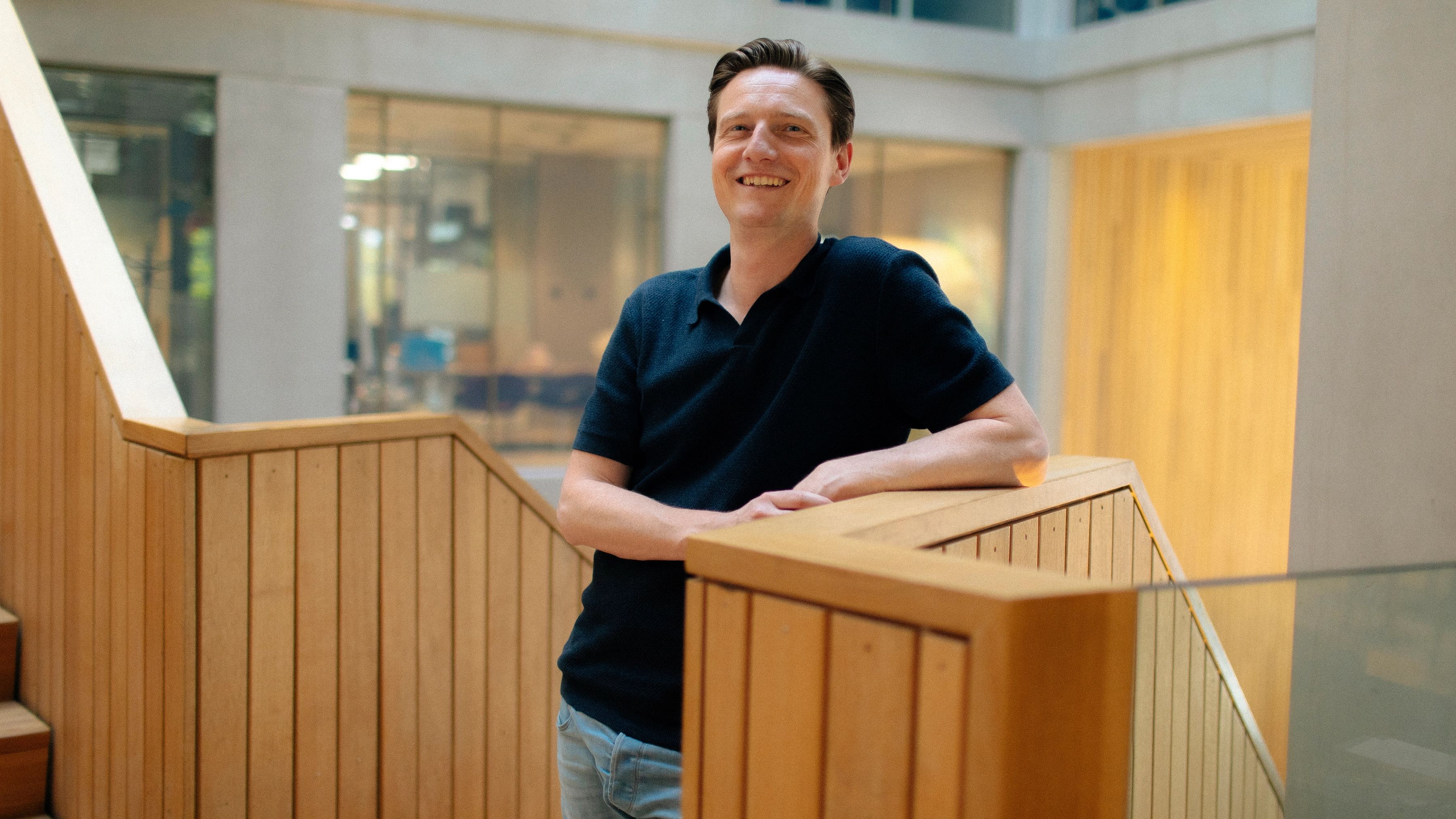 Sander leunt op een houten balustrade