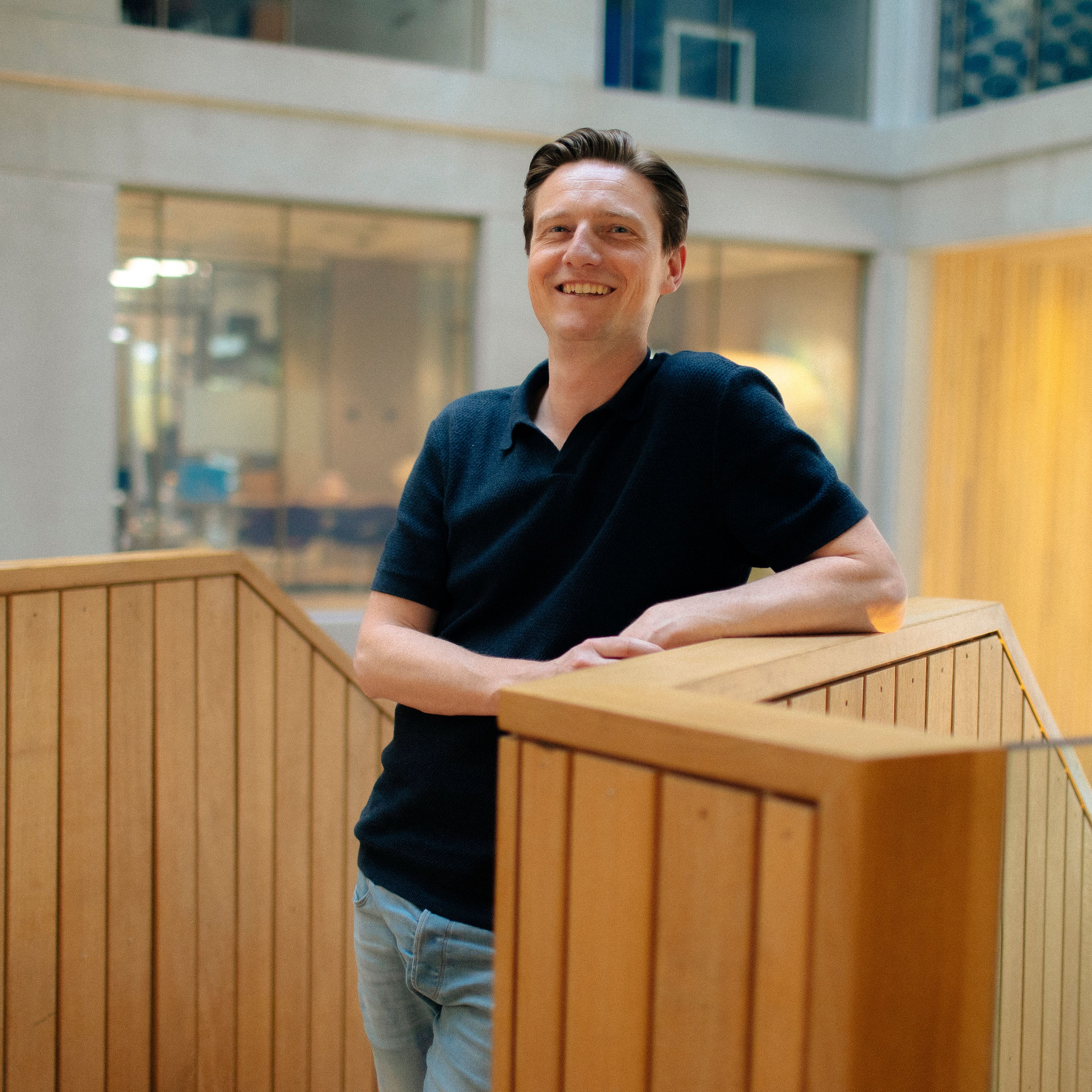 Sander Peltenburg leunt op houten trap