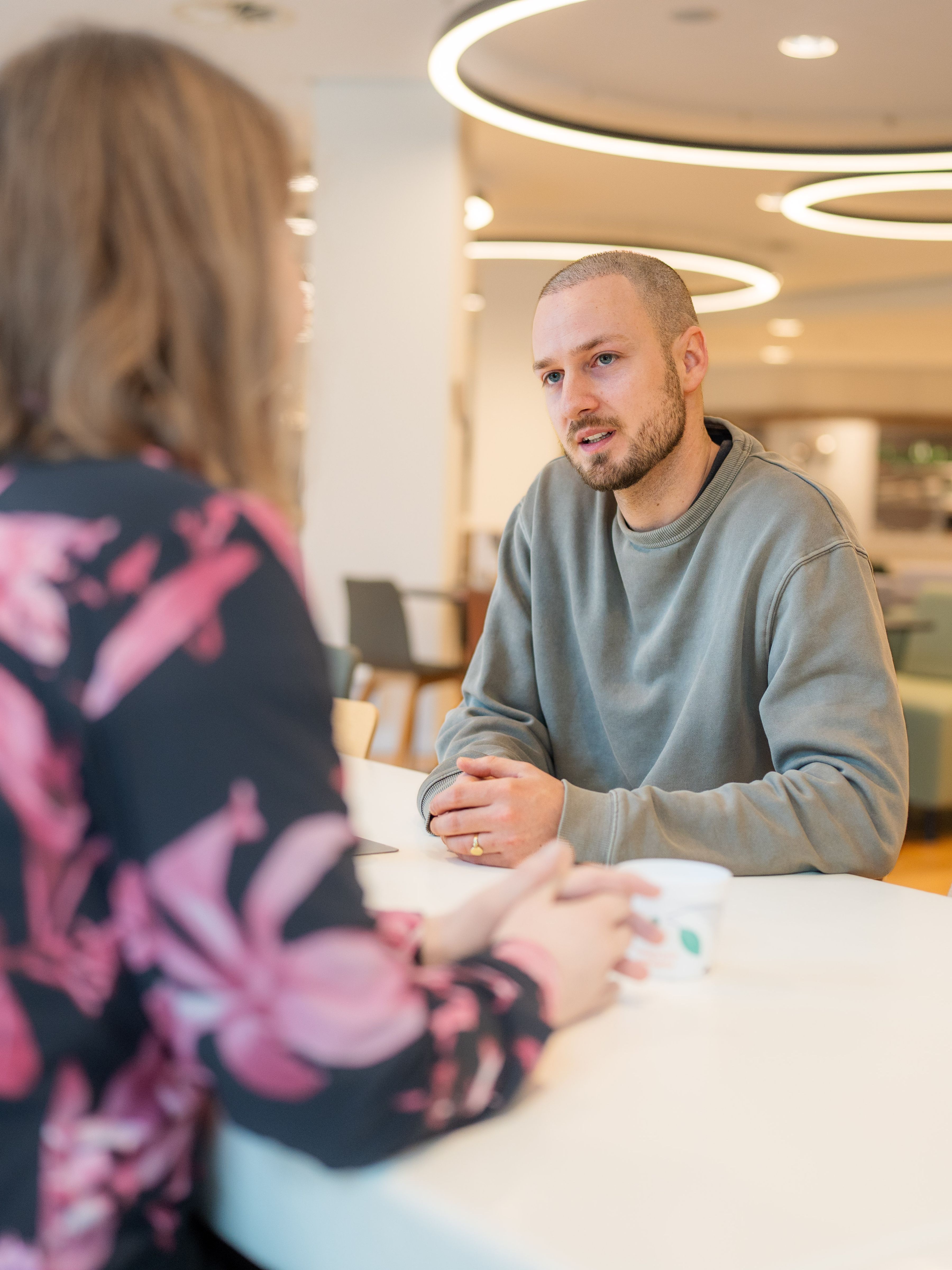man and woman chatting around a table