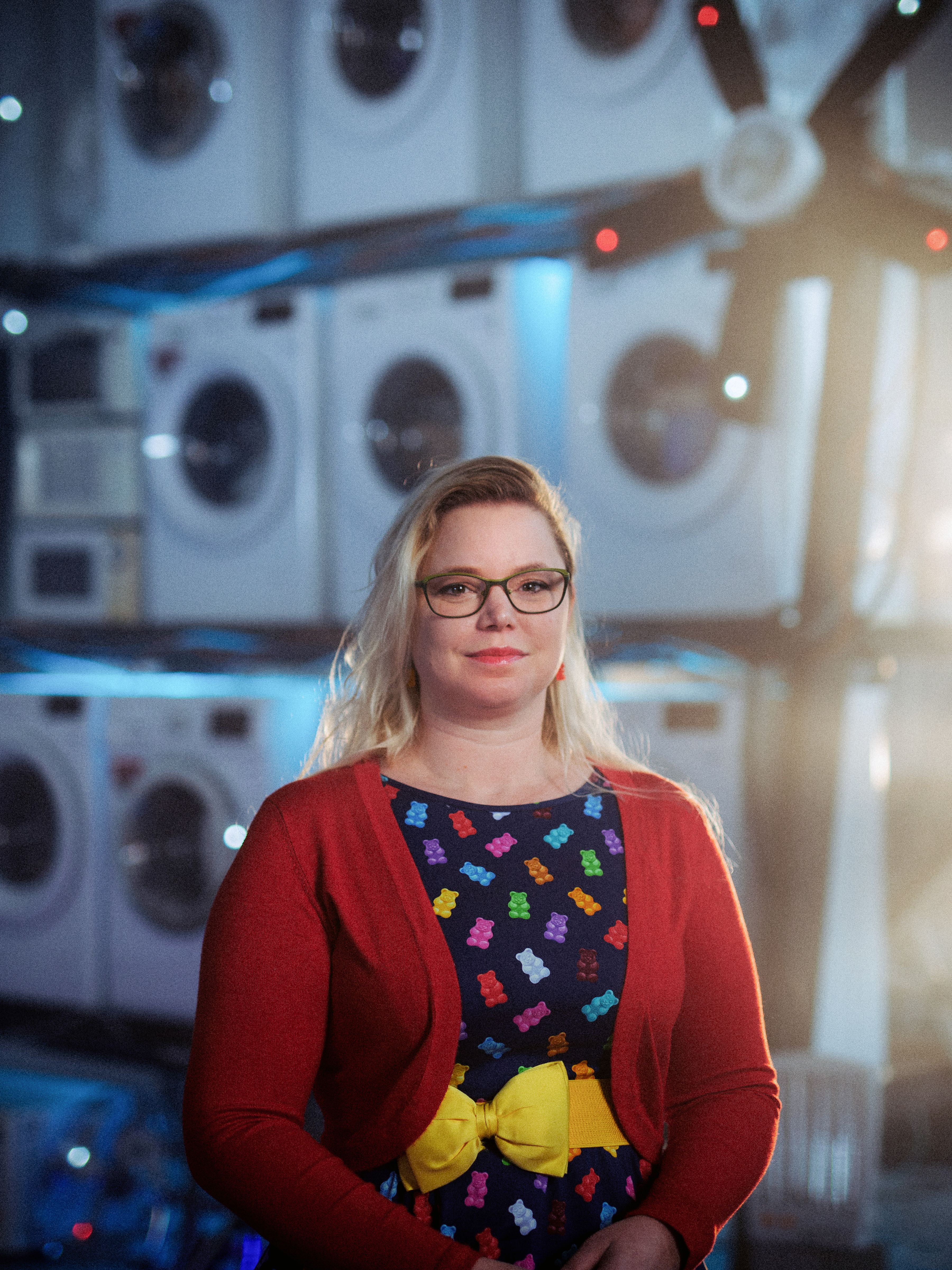 Woman standing in front of washing machines stacked up.