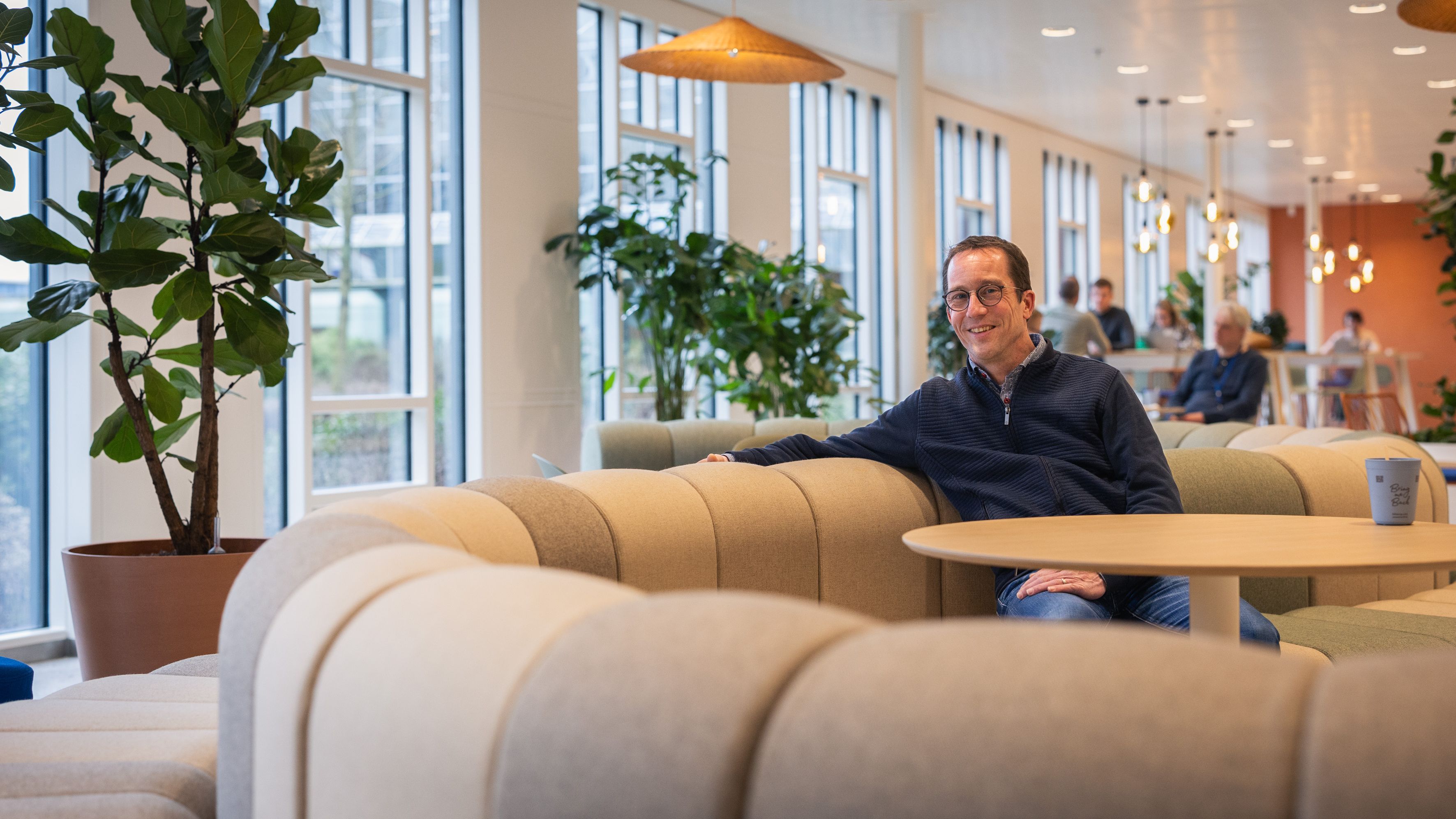 Man sits on the couch and looks into the camera