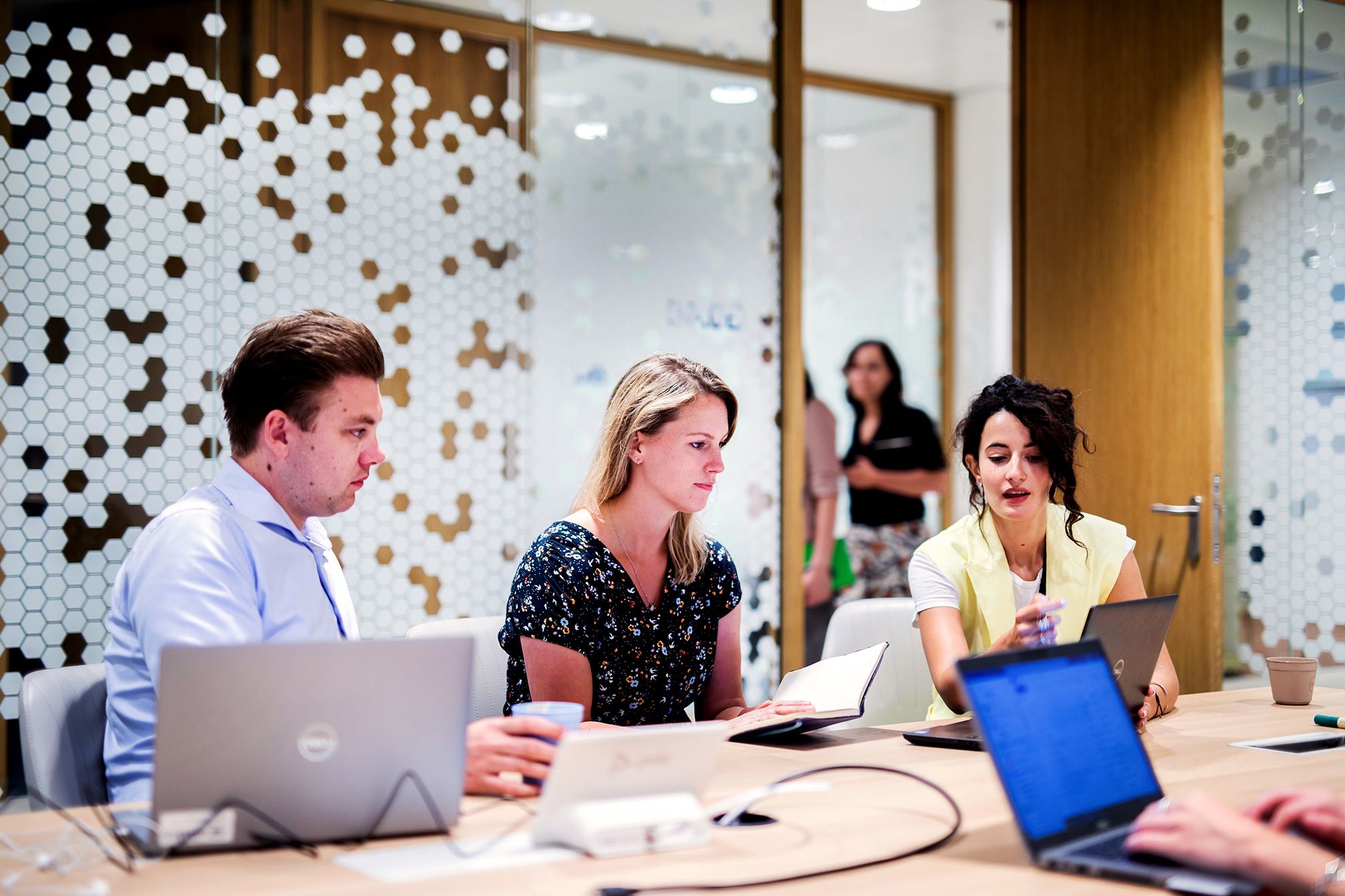 Vrouw aan het werk met collega in meetingroom