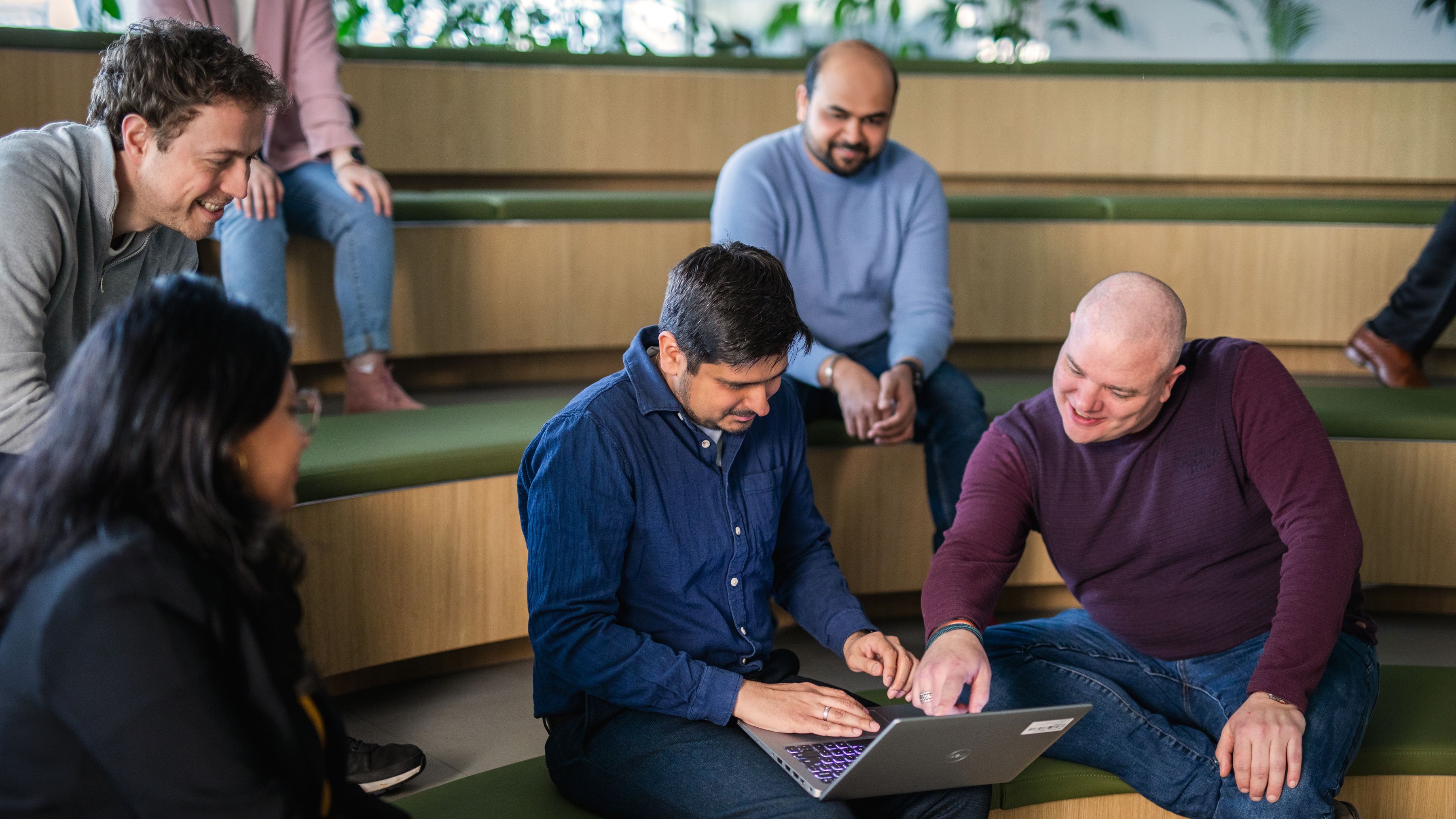Man working on computer in group of people.