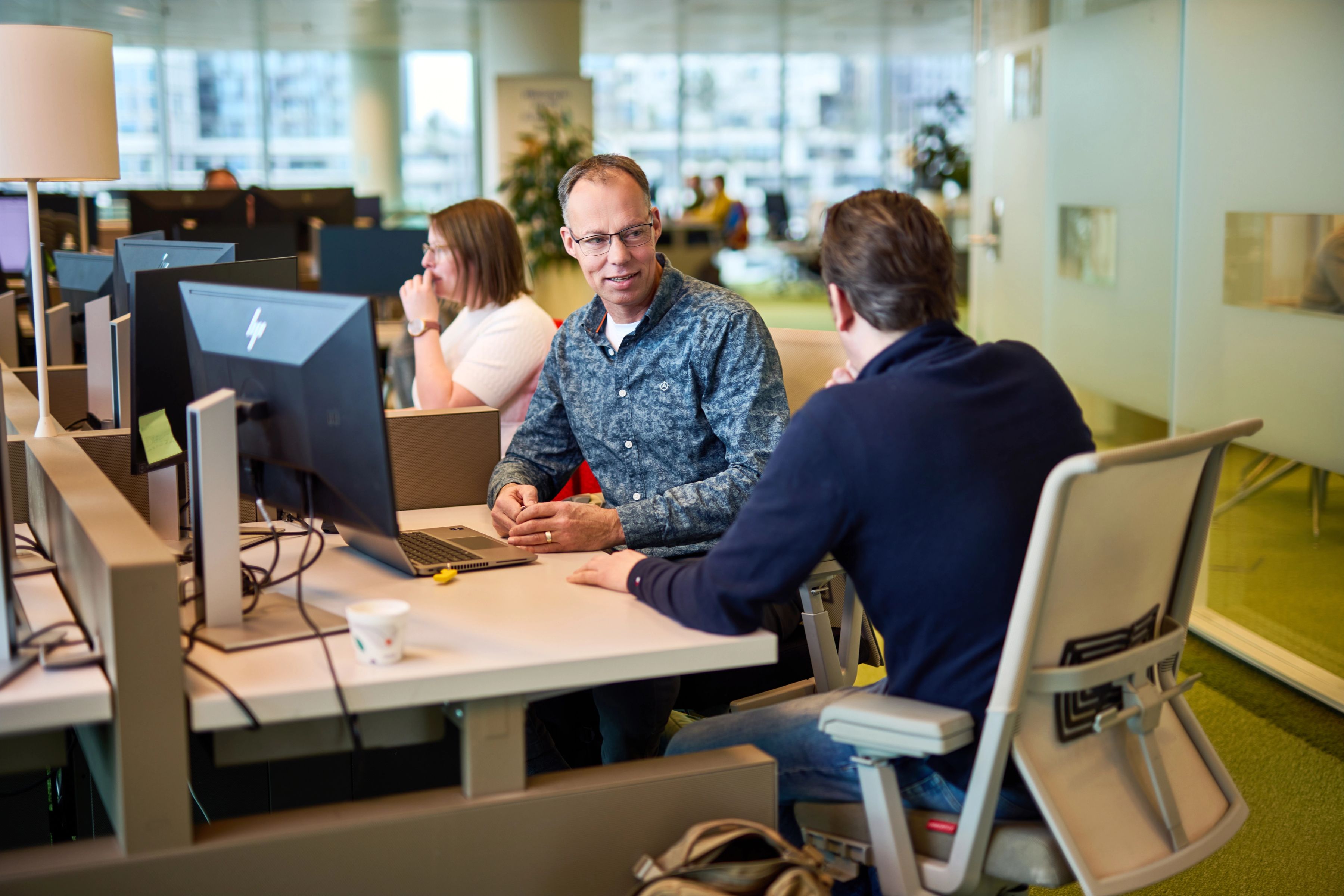 Arthur met een collega in gesprek op kantoor