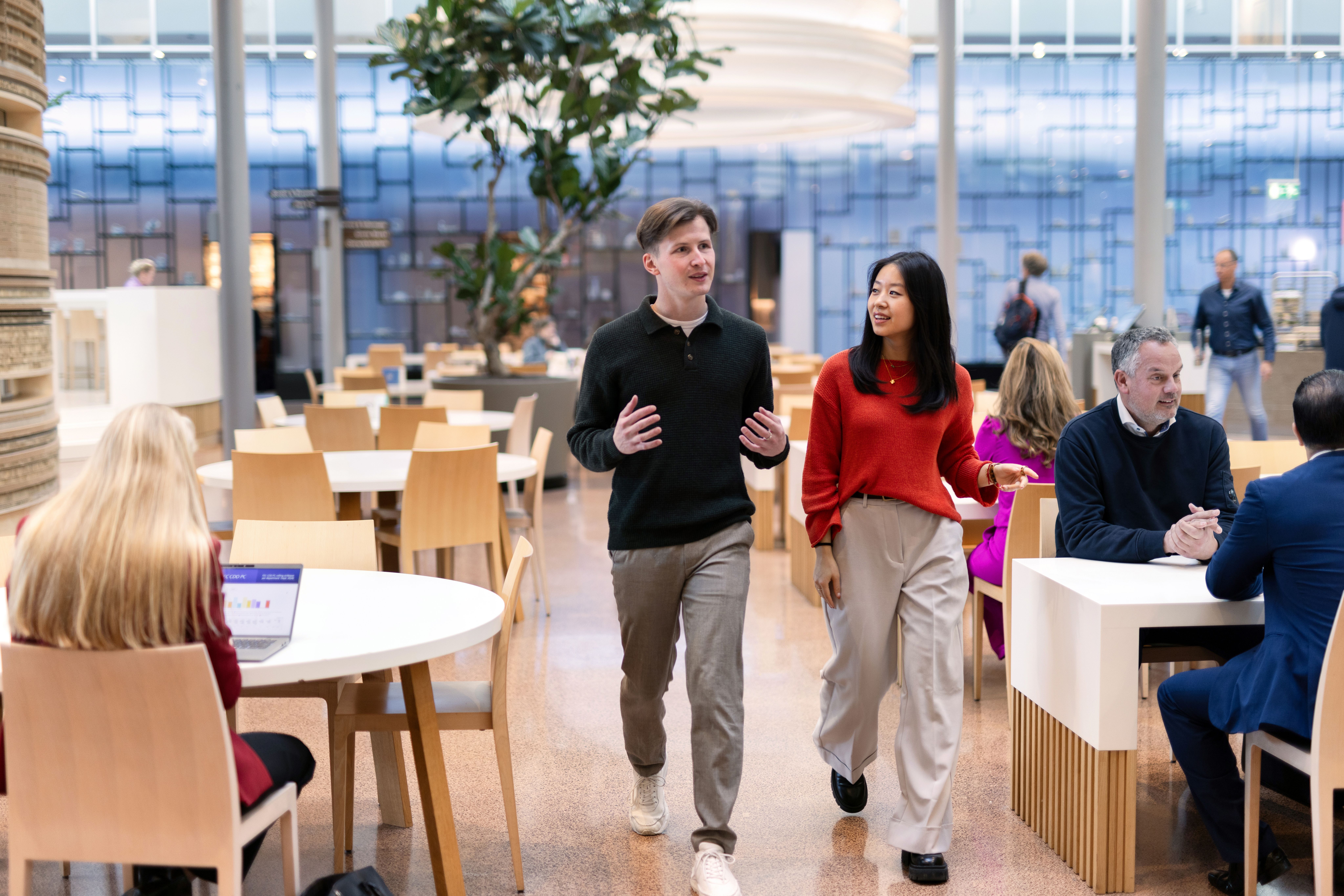 Mila loopt met collega door Rabobank restaurant