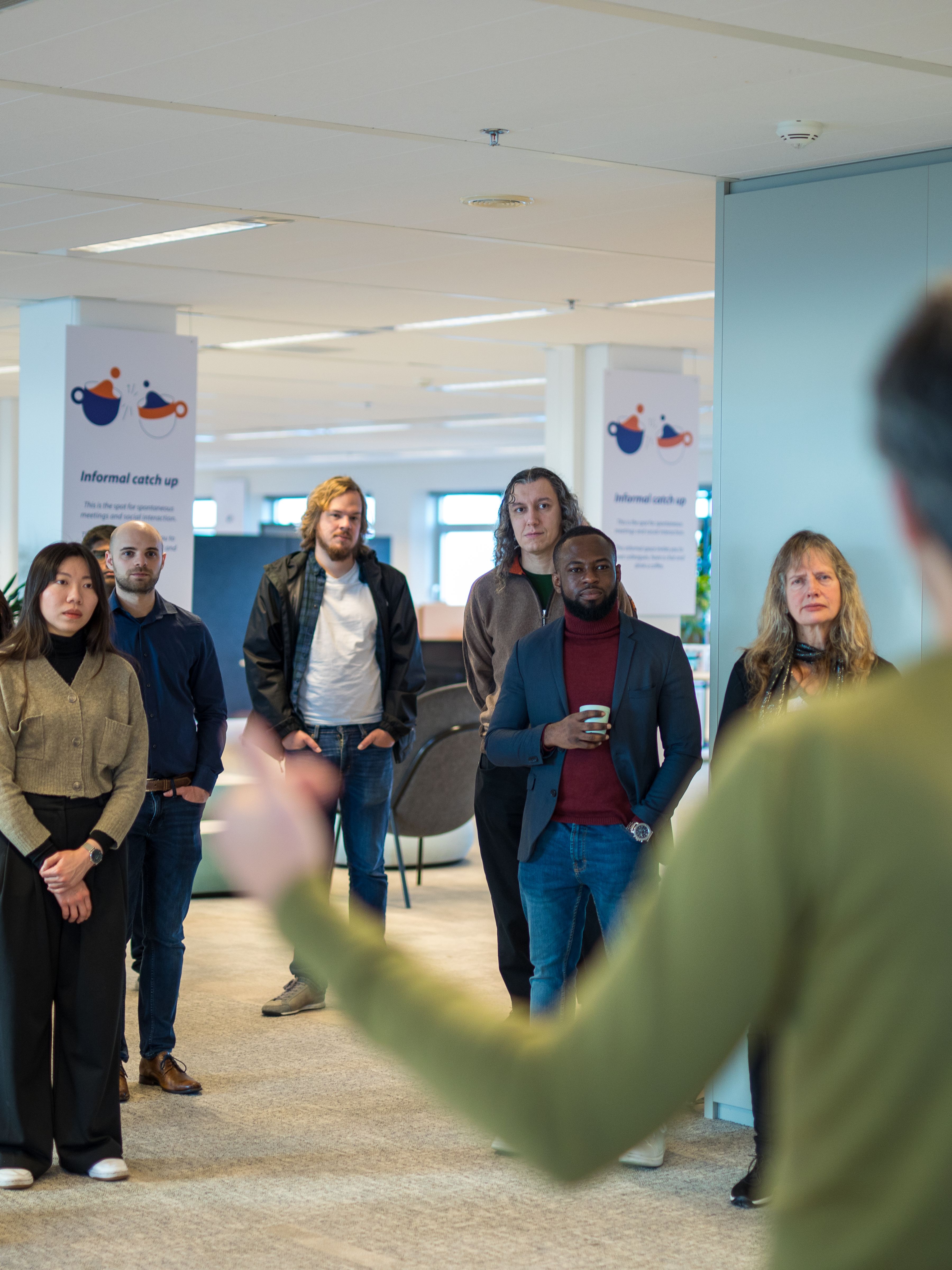 Man in green sweater presenting.
