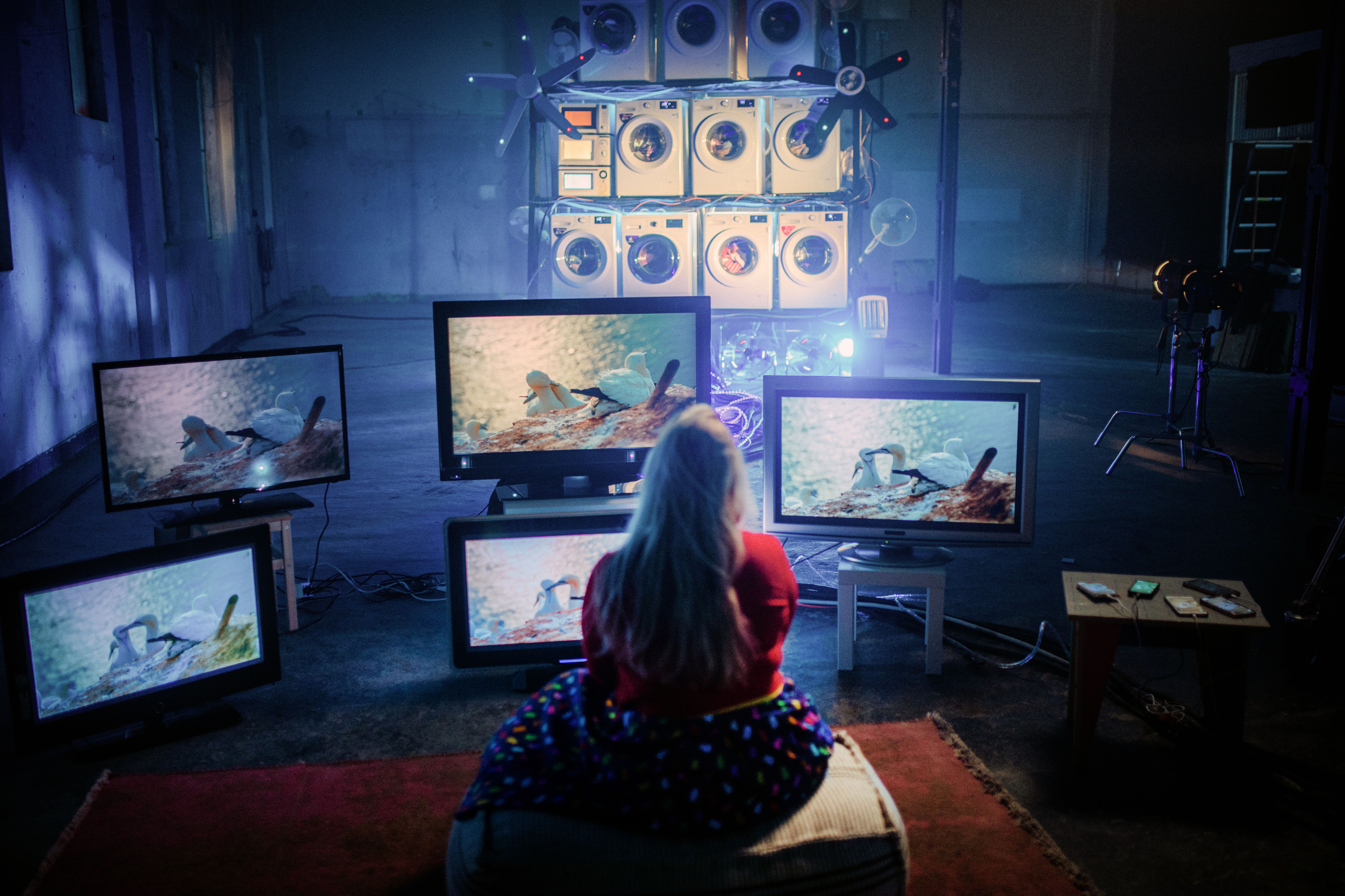 Woman in front of multiple large computer screens showing nature.