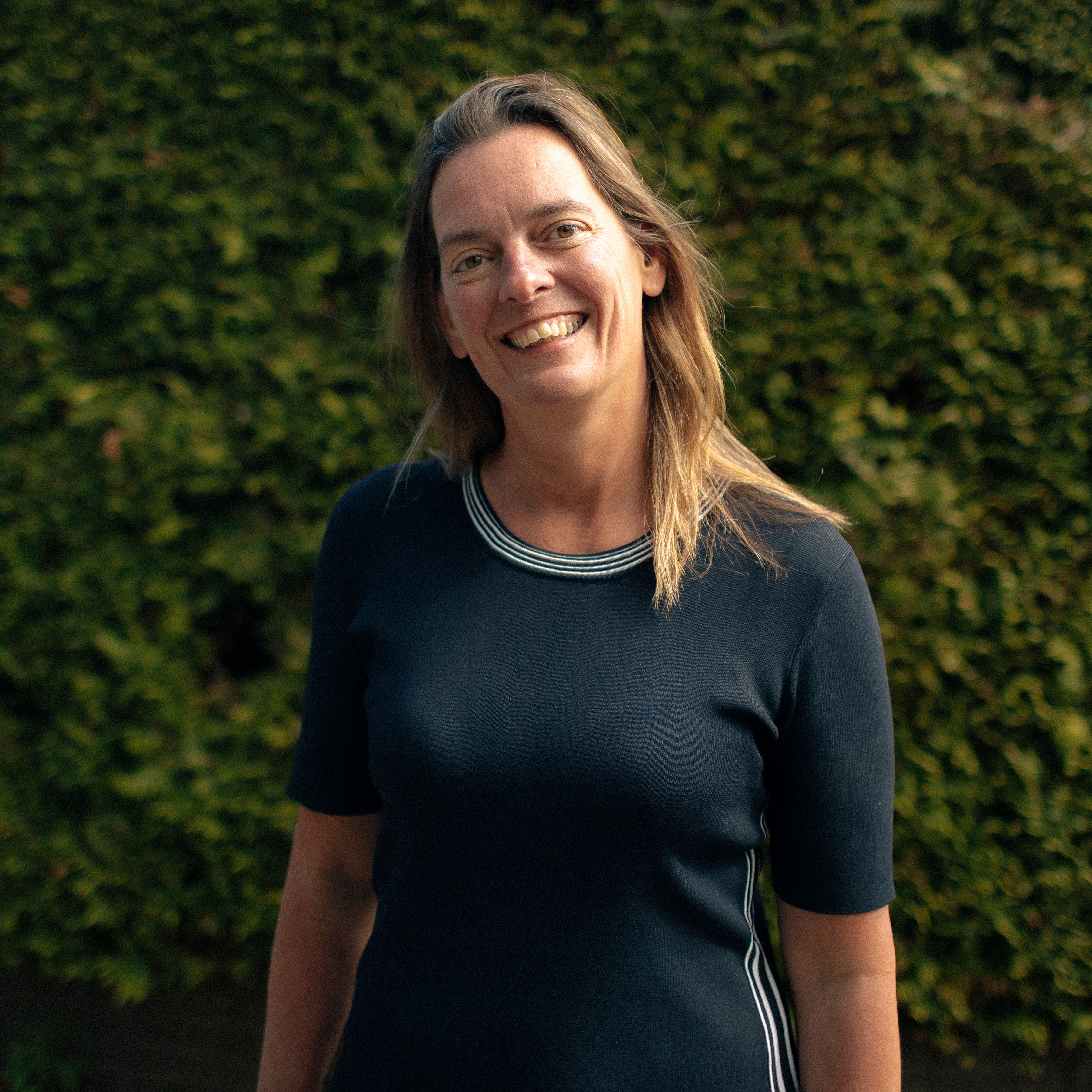 Petra staat voor een groene muur met planten