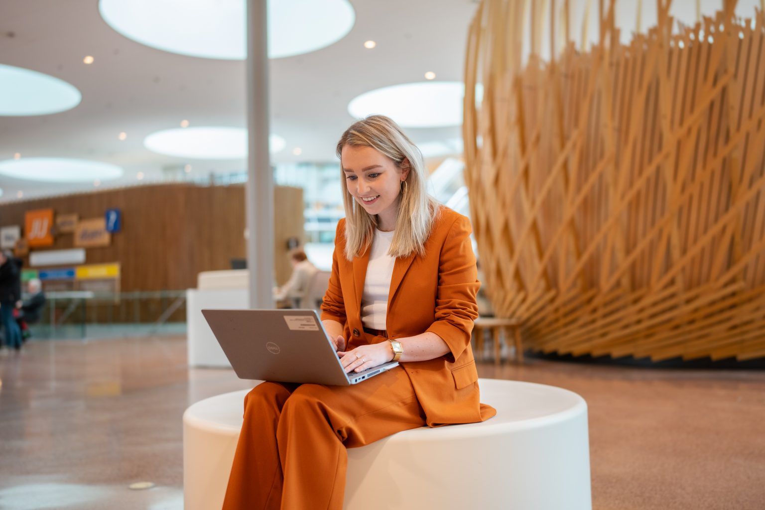 Jonge vrouw werkt achter laptop