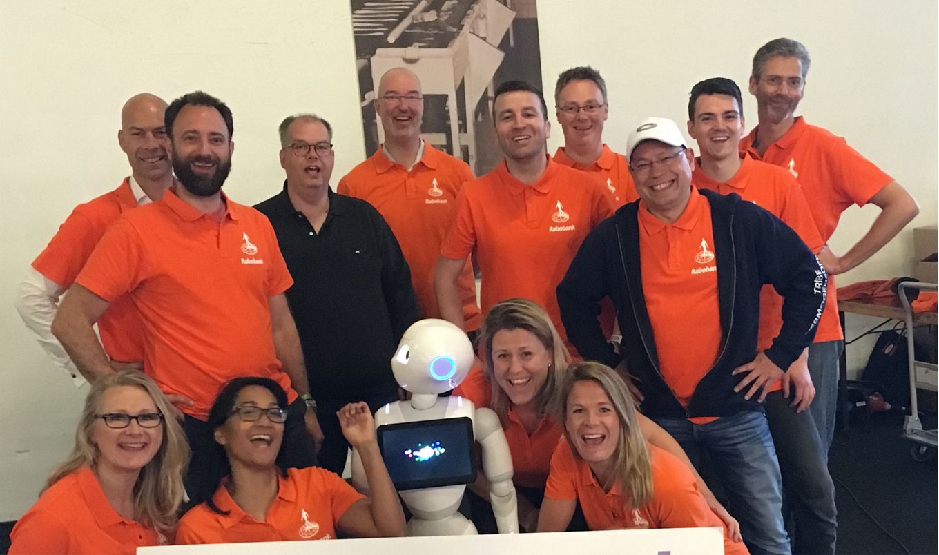Een team aan Rabobank collega's in oranje polo's 