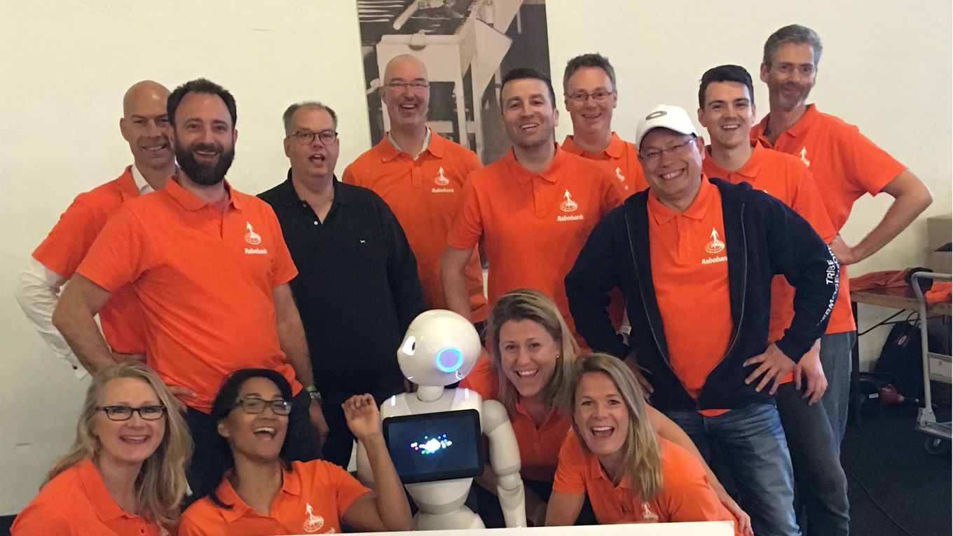 Een team aan Rabobank collega's in oranje polo's