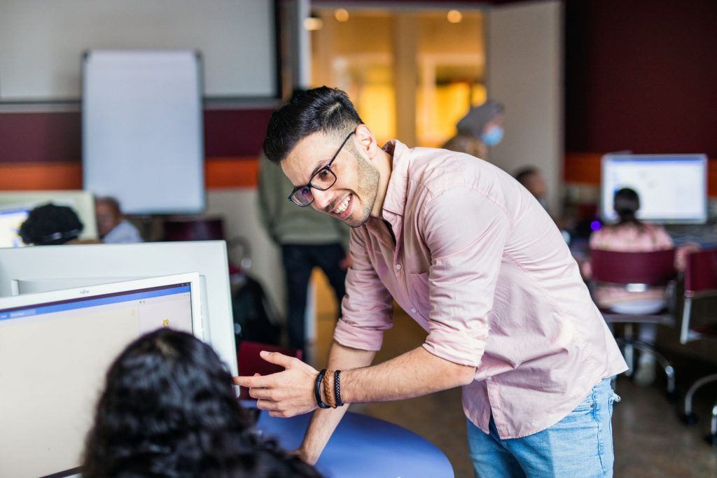 Young man with glasses explains something to a colleague