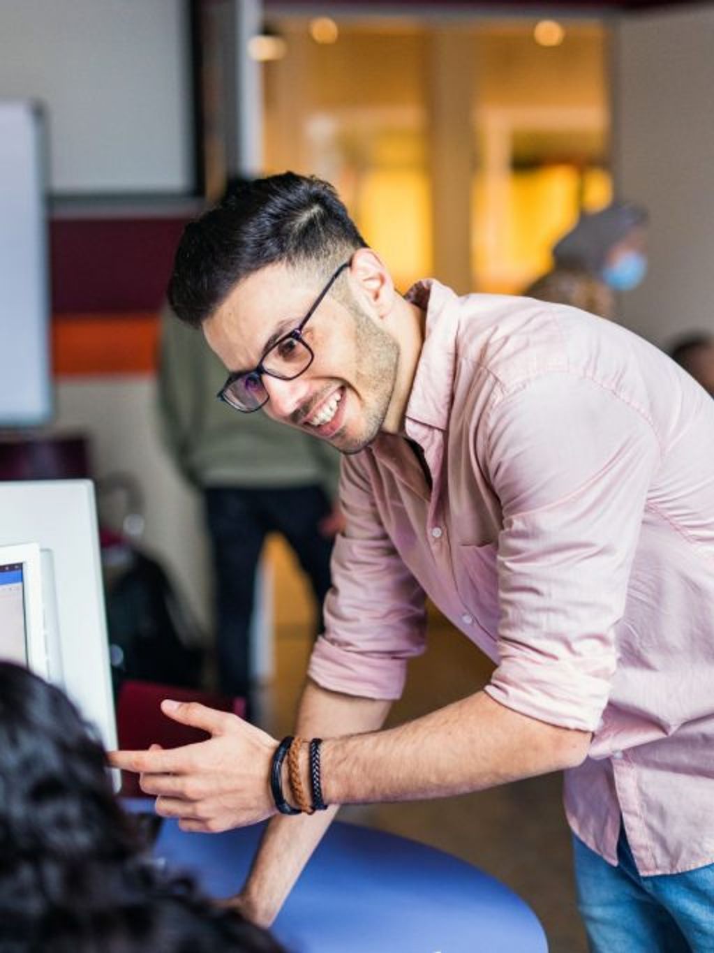 Young man with glasses explains something to a colleague