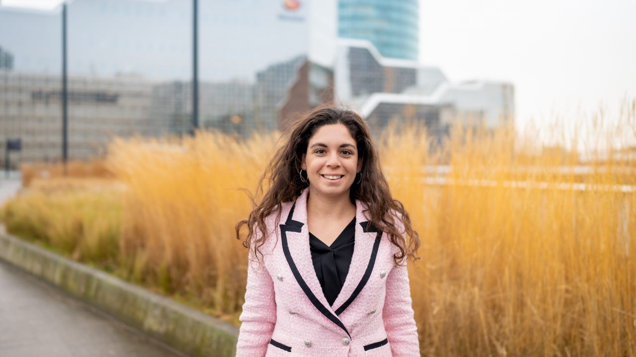 Young female professional is standing outside in front of Rabobank office