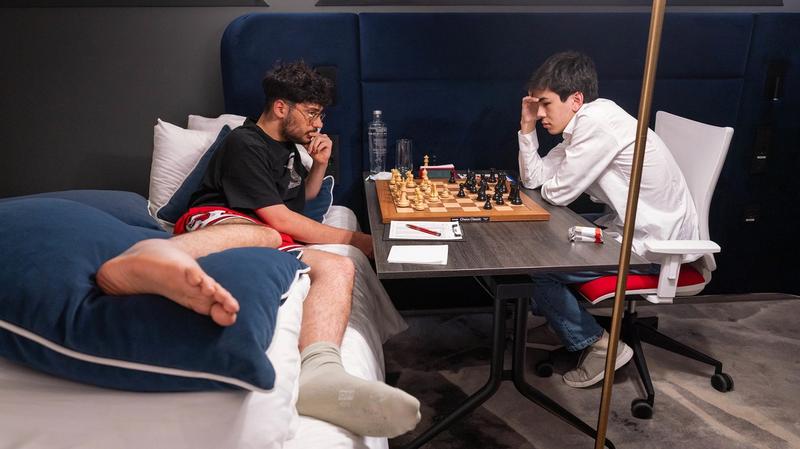 Firouzja spielt gegen Sindarov, während er im Bett liegt.