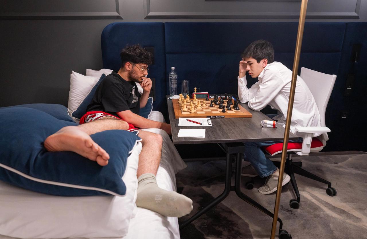 Firouzja 躺在床上与 Sindarov 对弈。摄影：Lennart Ootes/Grand Chess Tour。