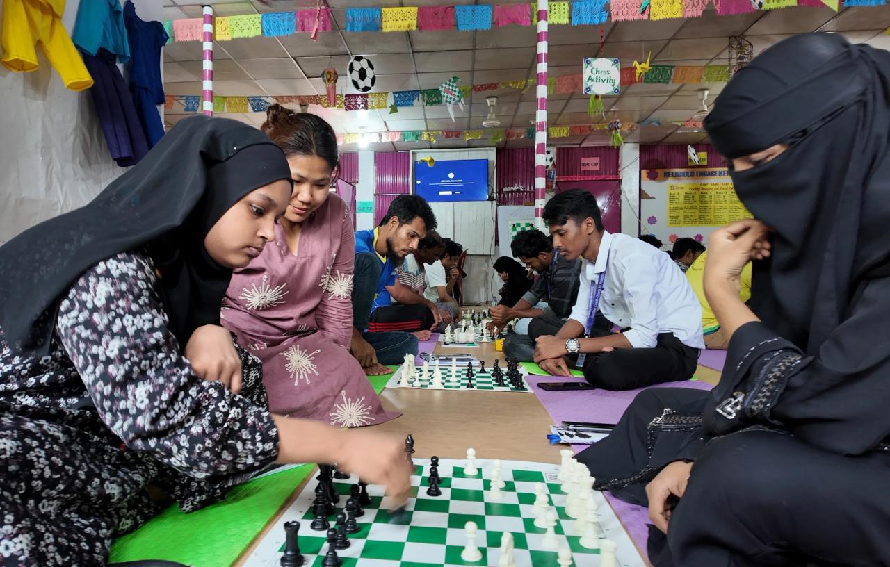 两名女学生在尼泊尔首位女子国际象棋冠军和WCM Monalisha Khamboo(左二)的注视下练习走法。