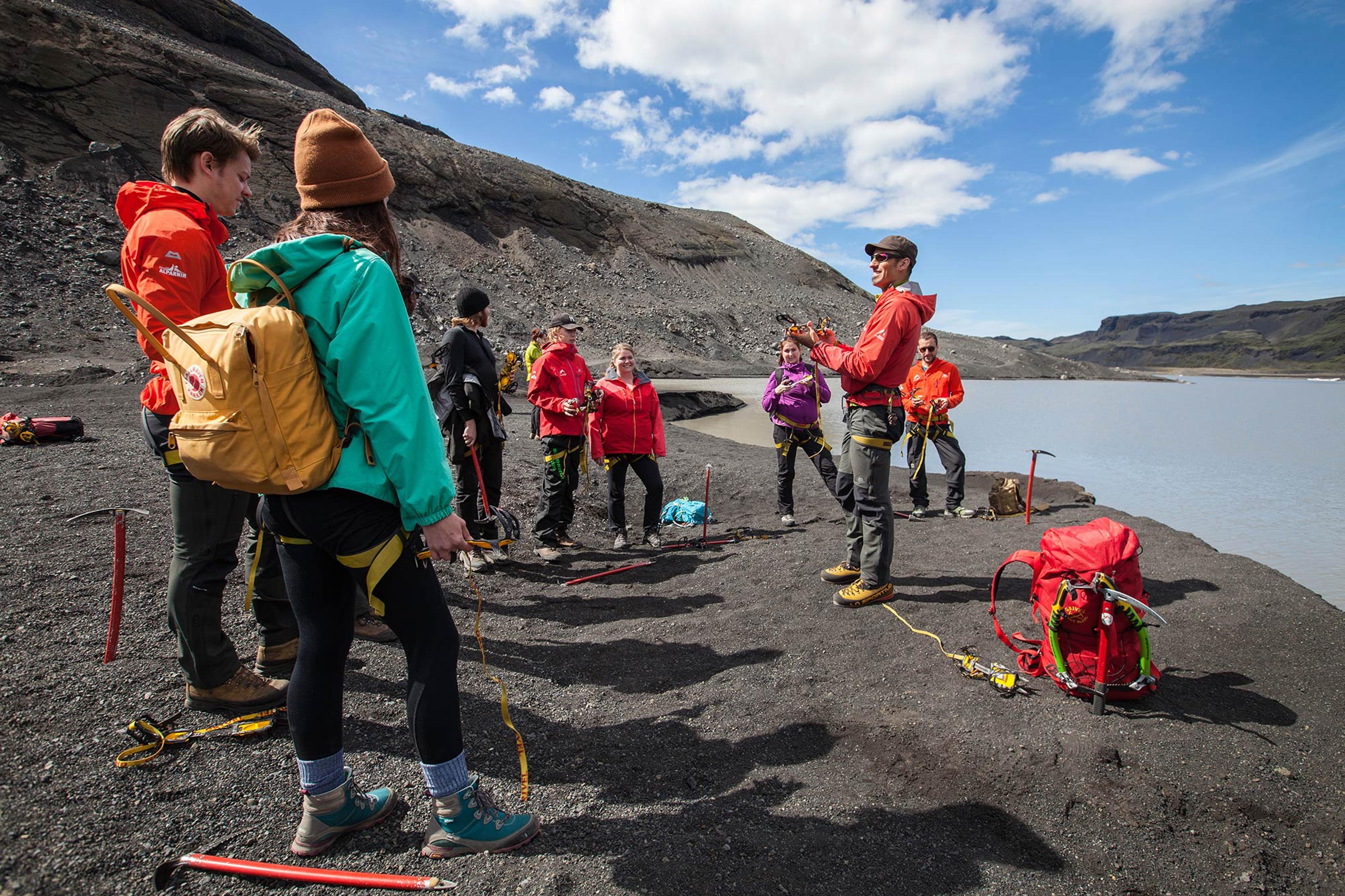 Guide from Icelandic Mountain Guides preparing a group for a glacier walk with river in background