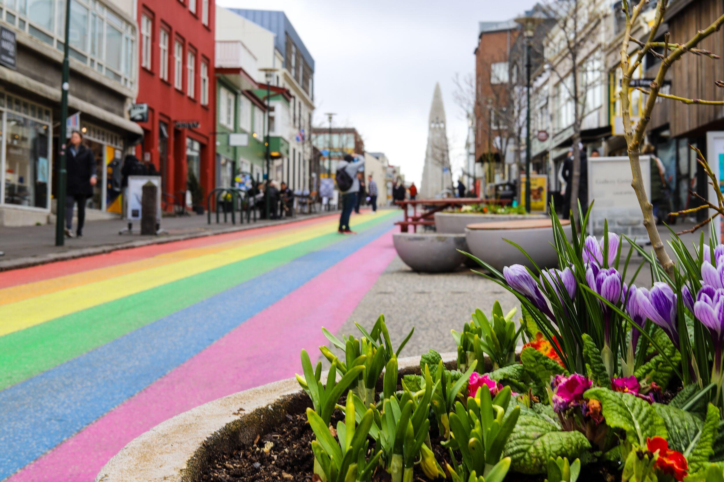 rainbow colored street going towards a church