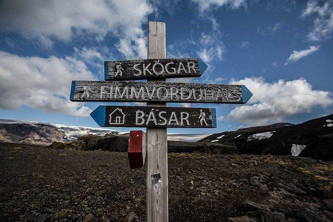 A sign pointing to the direction of Skógar, Fimmvörðuháls and some booths