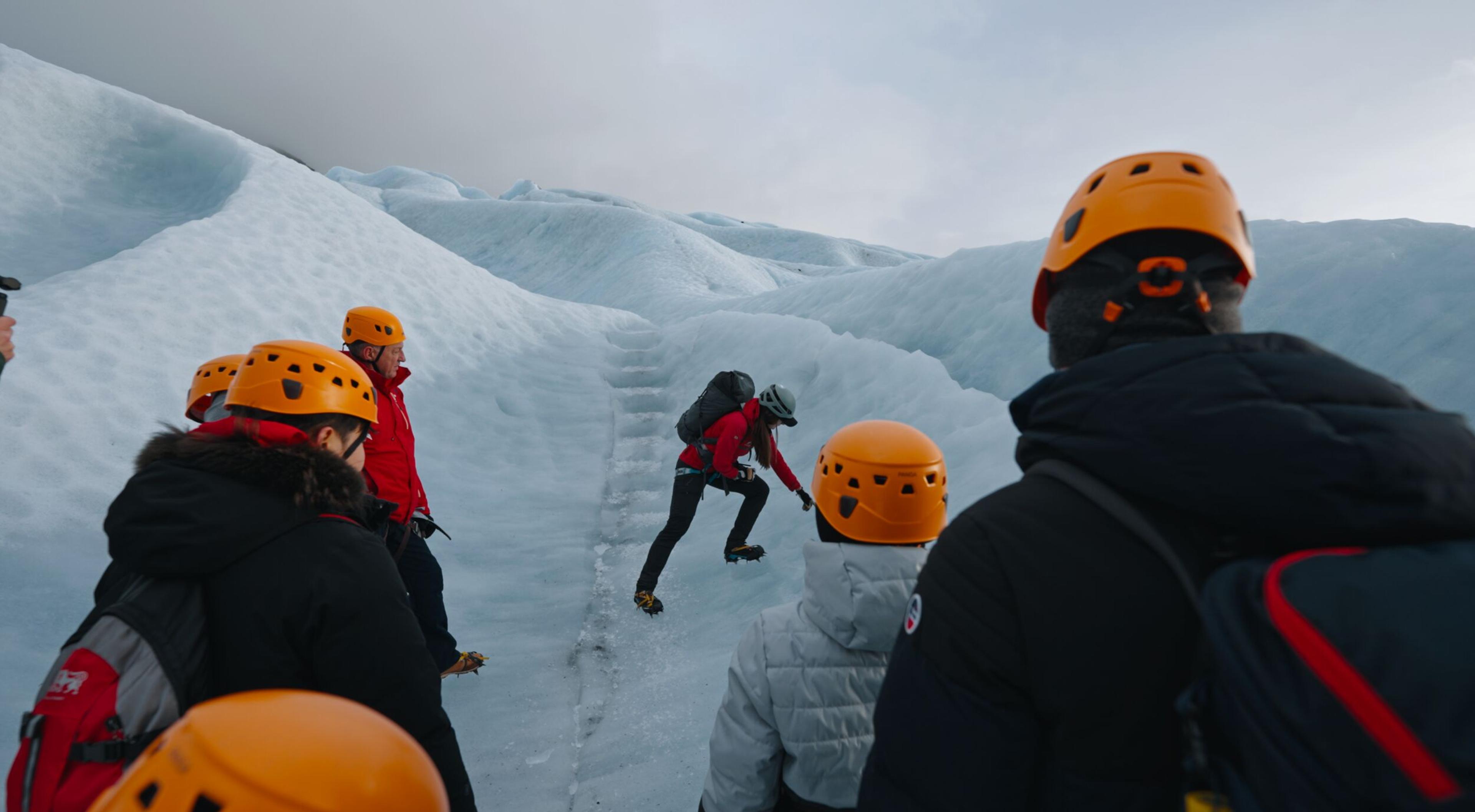 A glacier guide explaining something about glaciers on a glacier hike with a group of people
