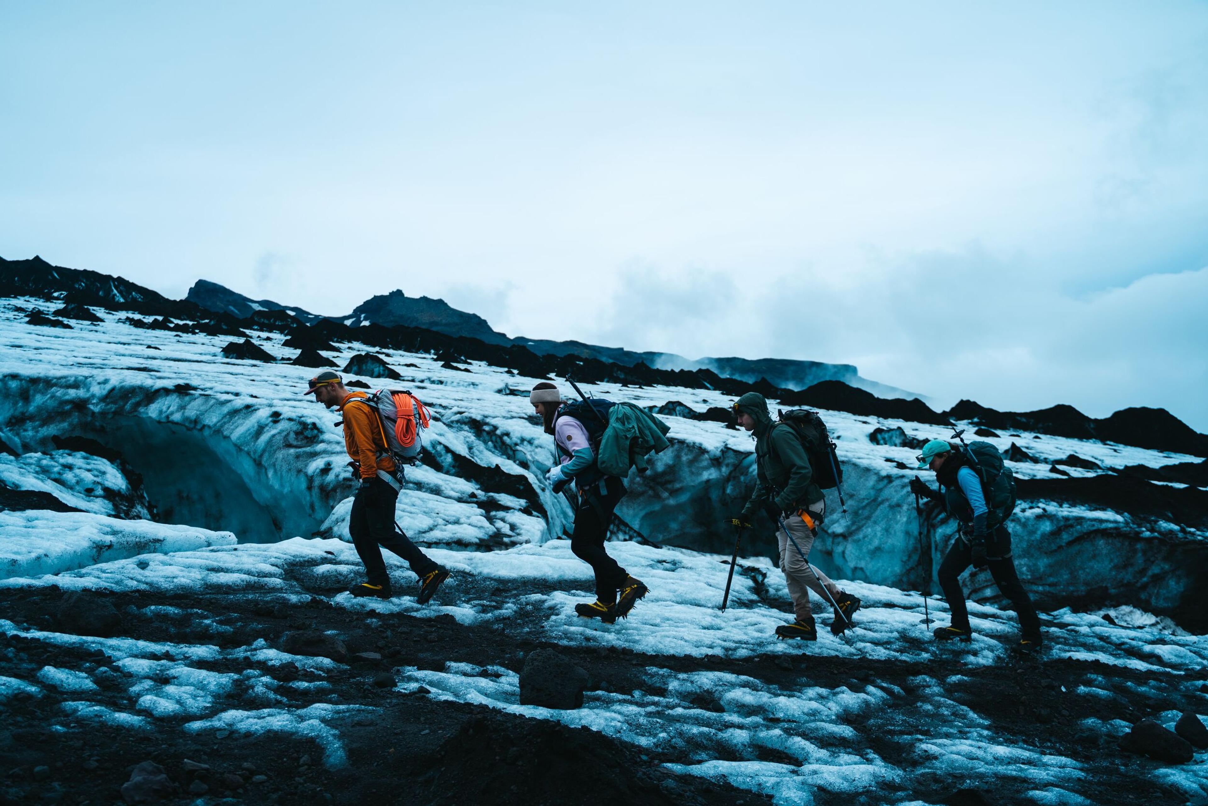 Four hikers cross the ash-strewn glacier ice of Eyjafjallajökull