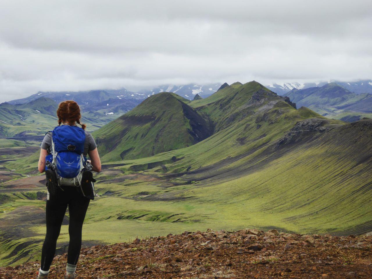 Picture of a girl enjoying the view of moss covered mountains in Iceland