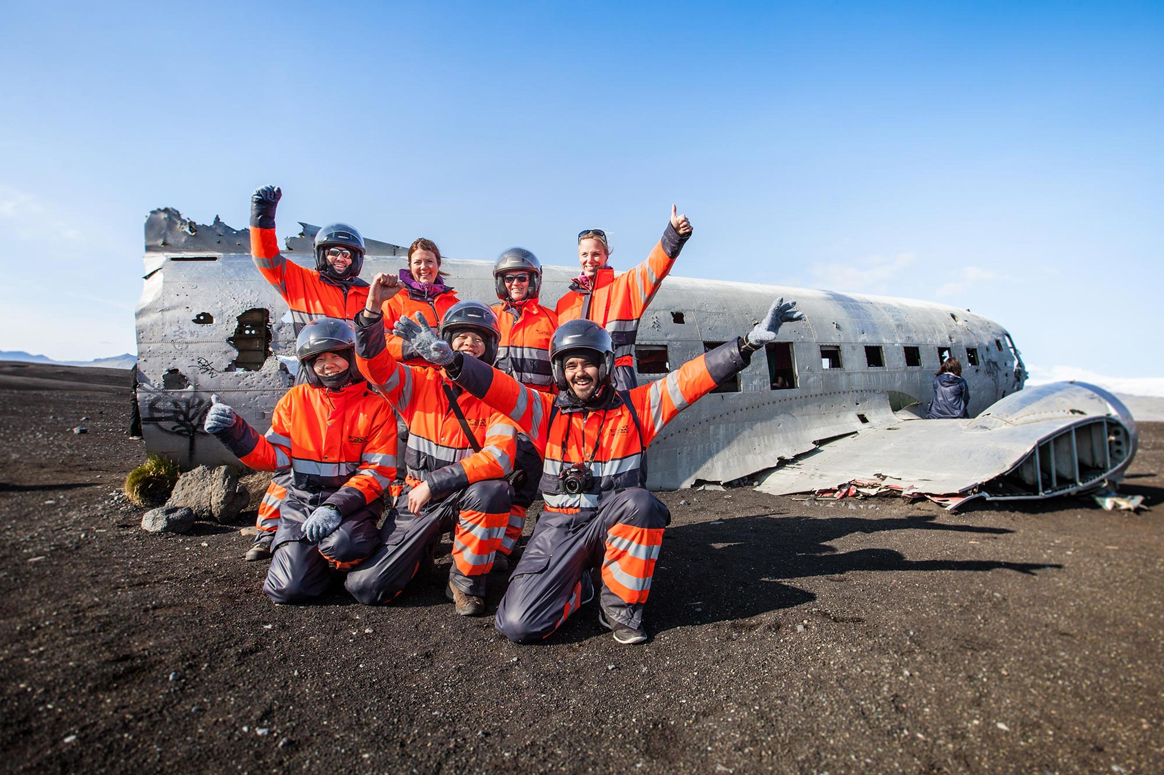 Group of people posing for a selfie in front of an old plane wreck on Sólheimasandur in Iceland