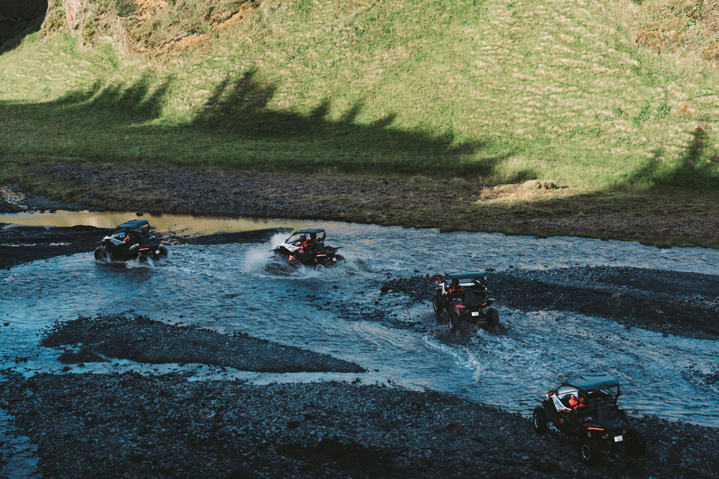 four buggys driving over a river