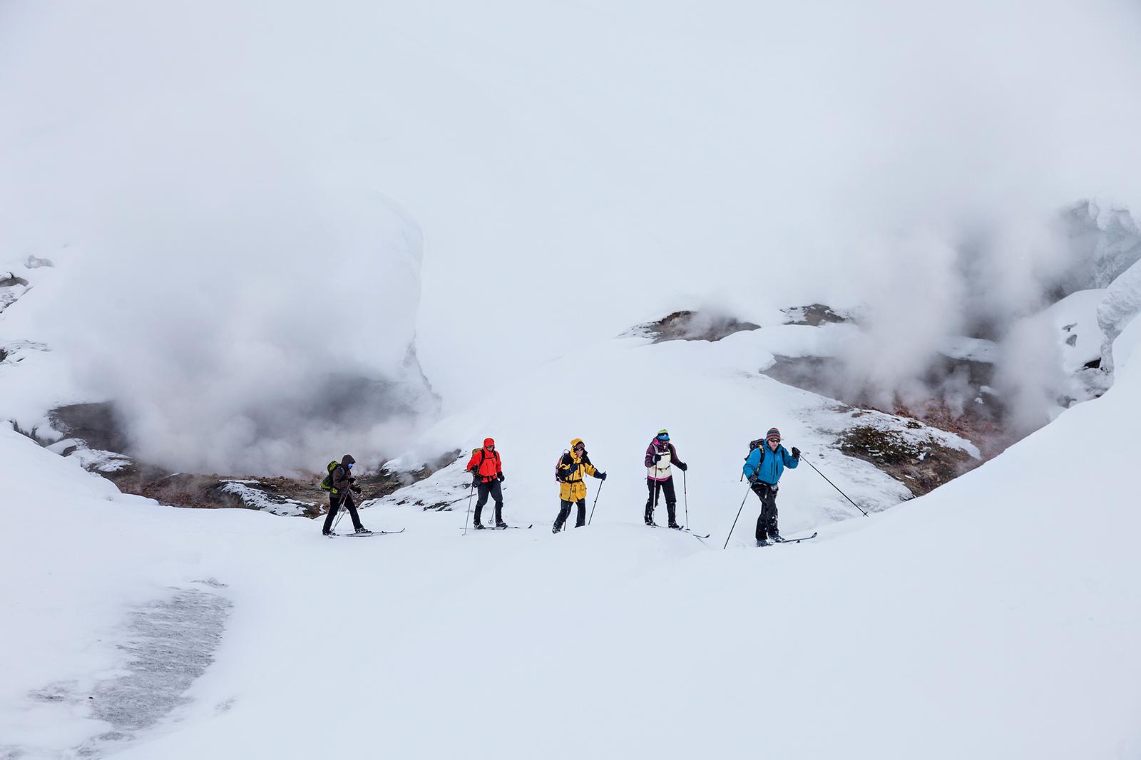 Group of people trekking wearing skis in Landmannalaugar with beautiful fog in background