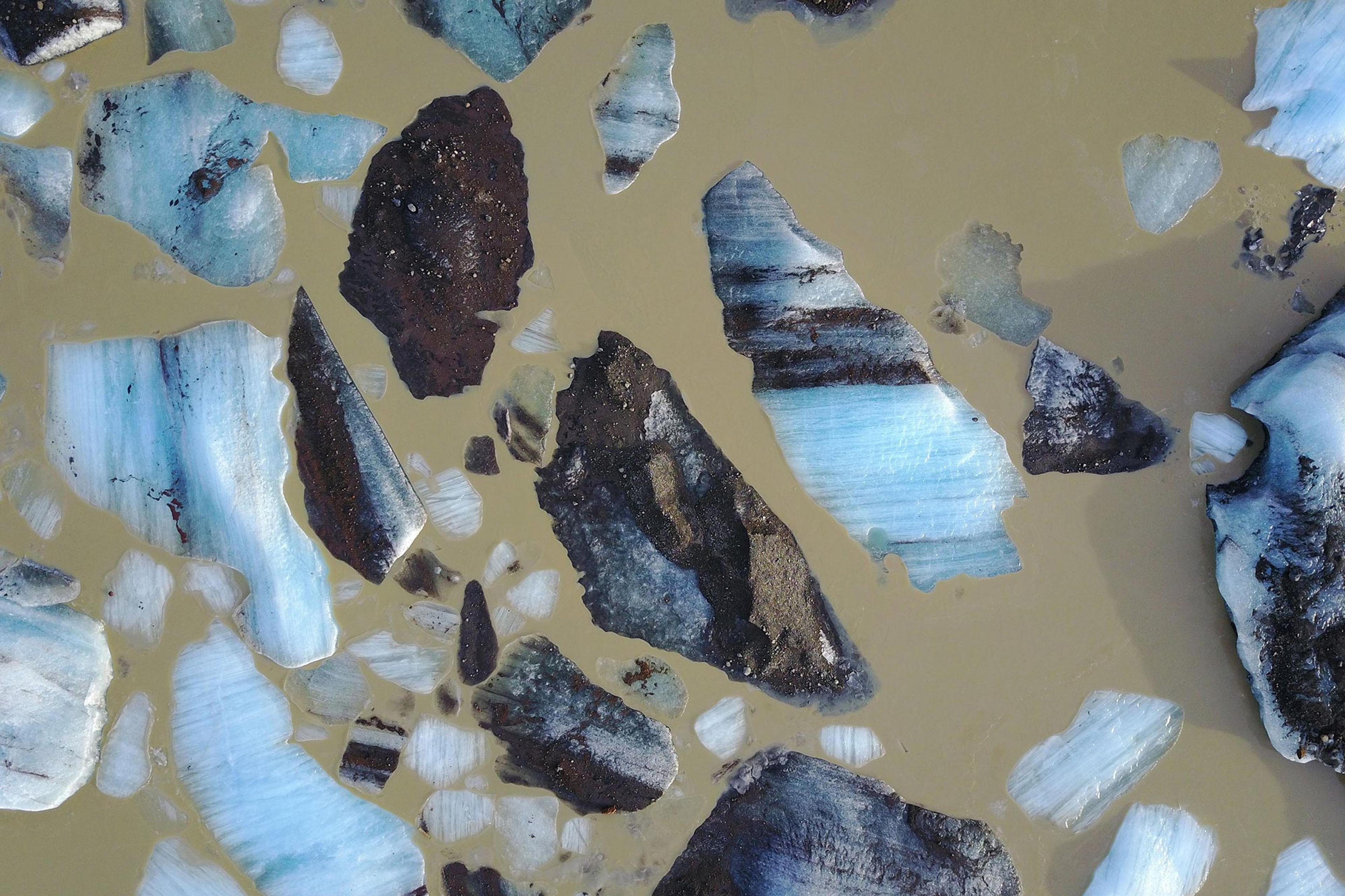 A bird’s eye view of multi-colored icebergs floating in a glacier lagoon