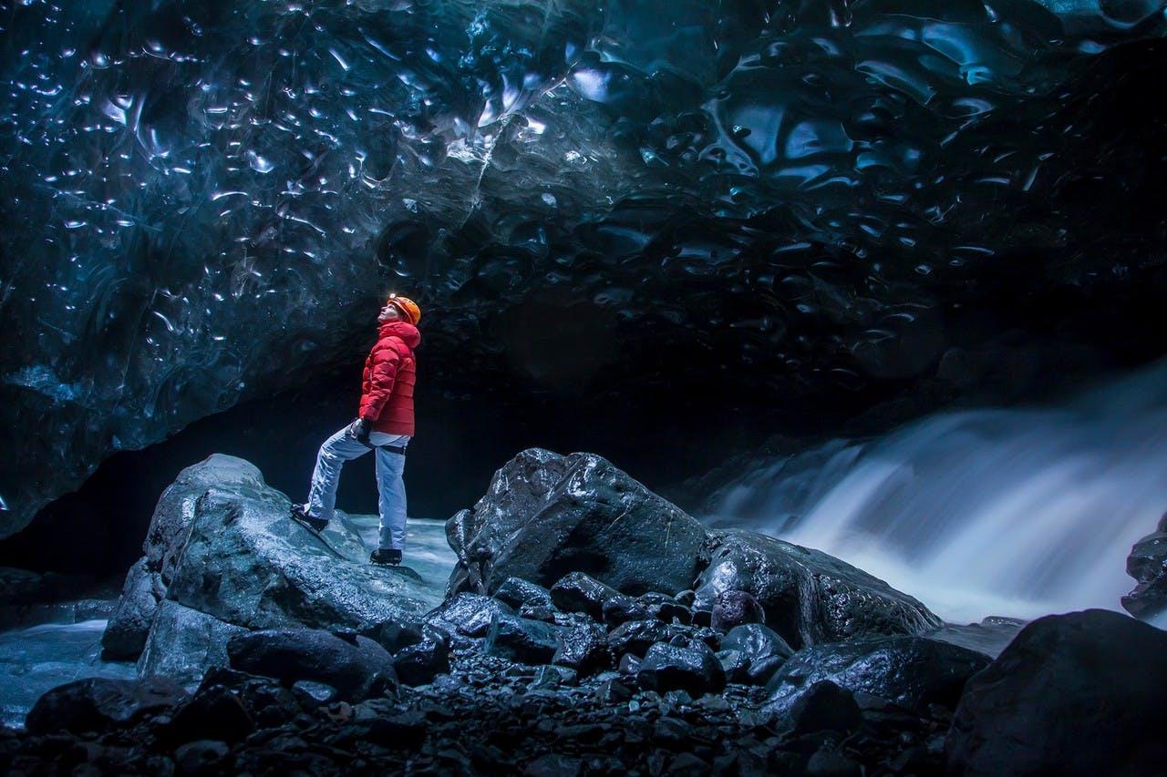 A person ina red jacket in a beautiful Ice cave