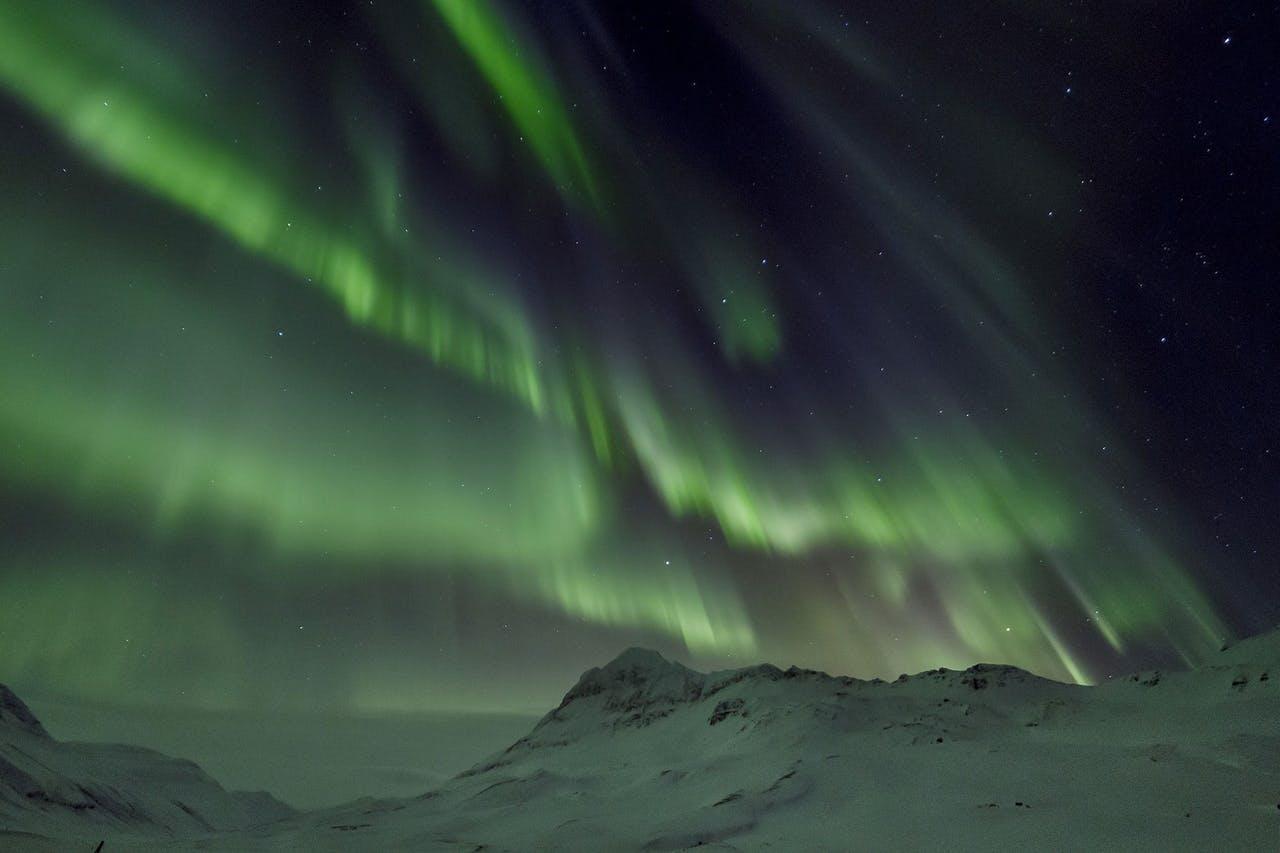 Northern lights over snowy mountains in Iceland