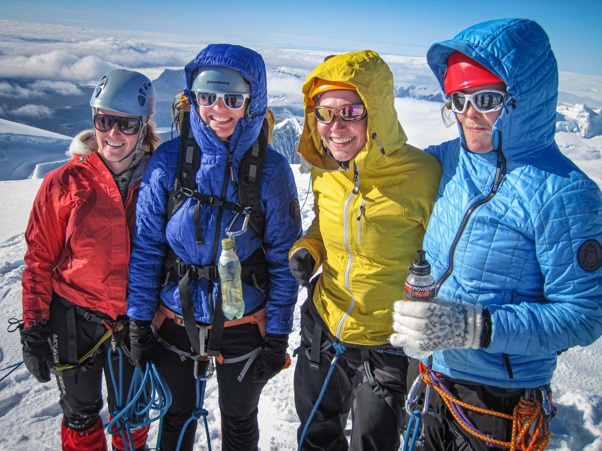 four happy hikers on a snowy mountain