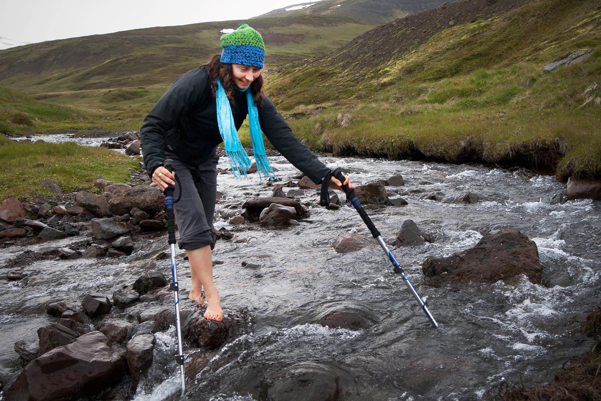 A woman river crossing barefoot in Iceland