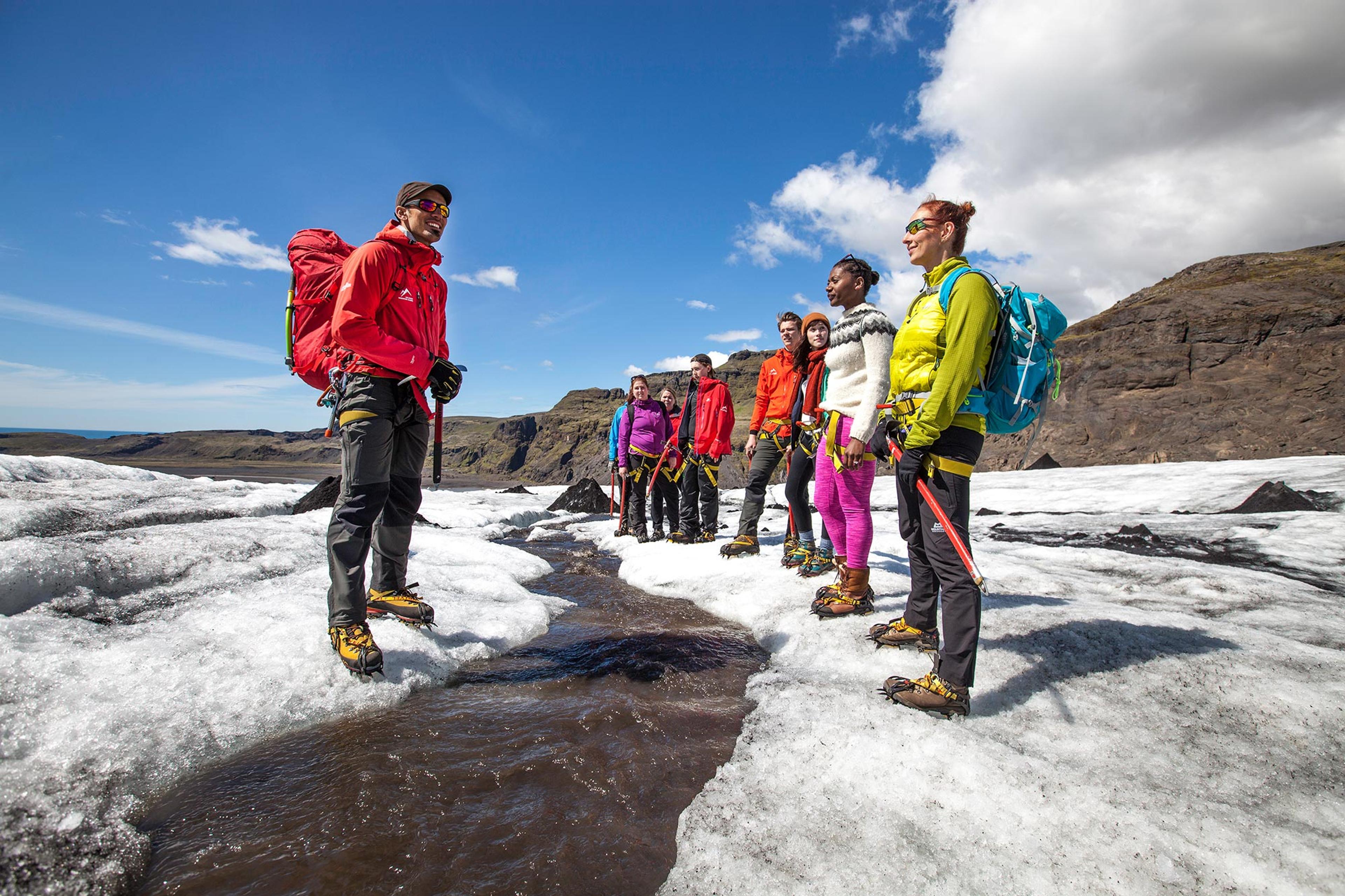 Guide from Icelandic Mountain Guides with tourists next to small river on Sólheimajökull