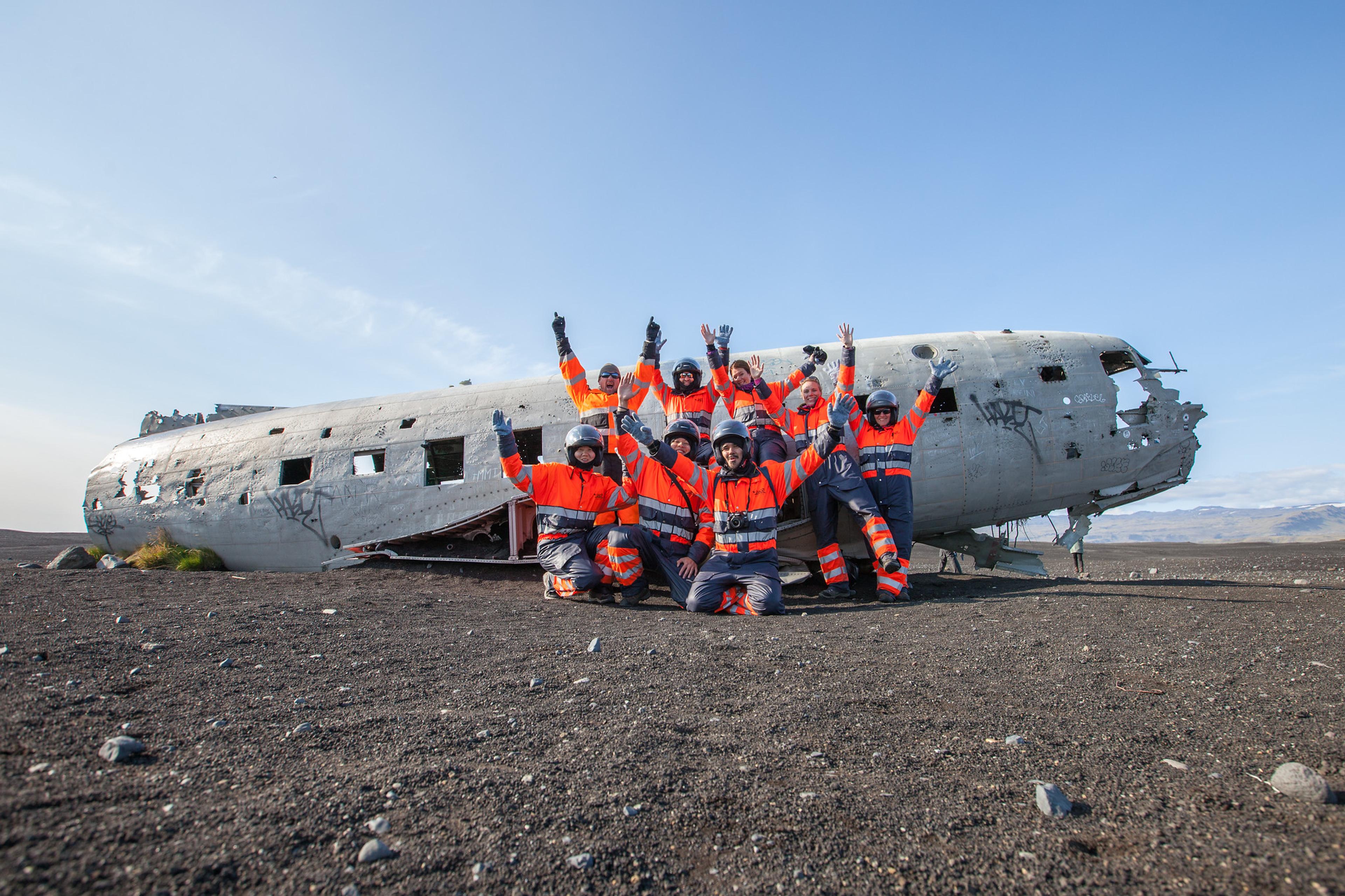 A group photo of people in front of the famous old dc3 plane wreck on Sólheimasandur