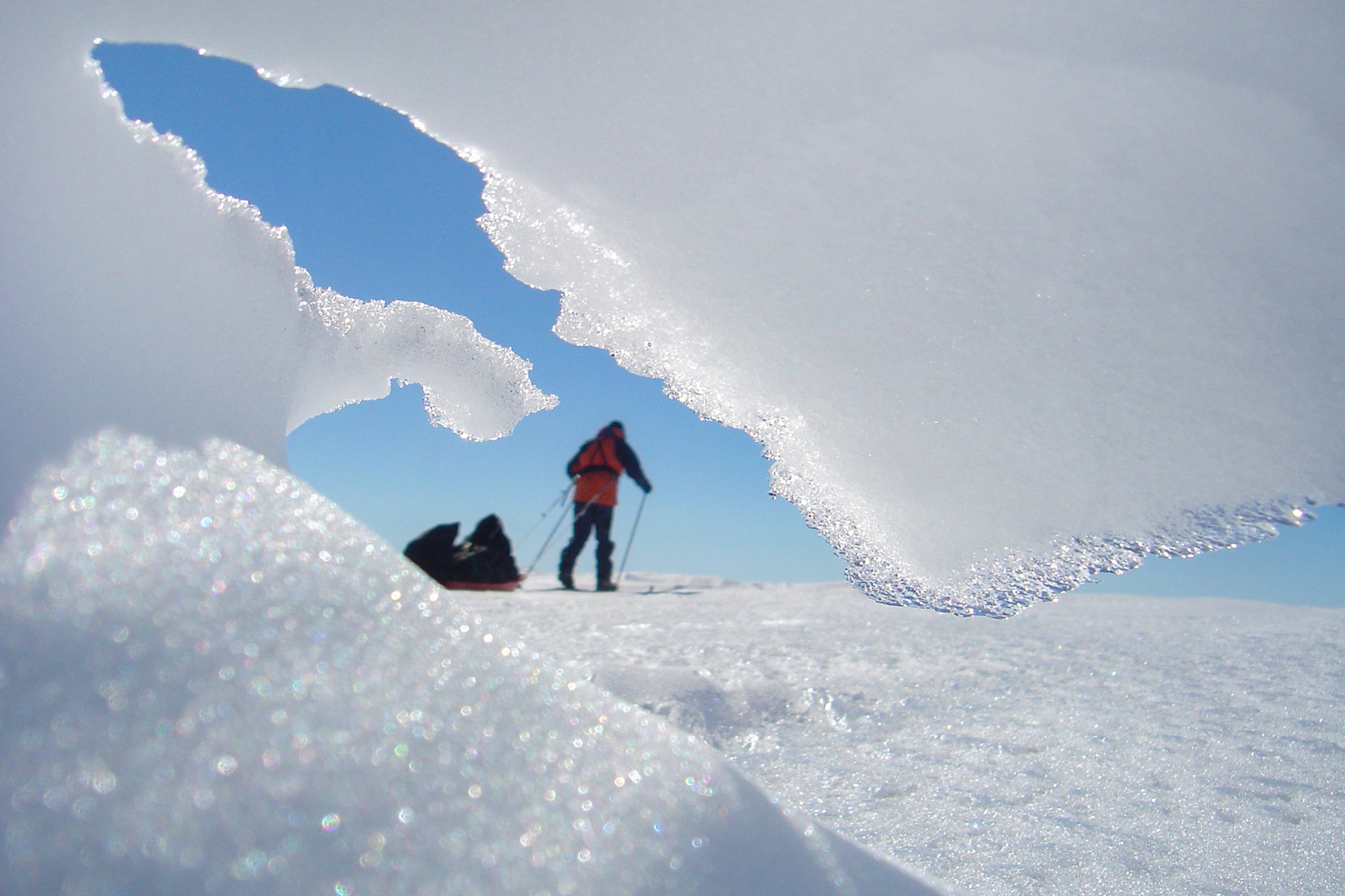 A skier going past a snow formation on the glacier
