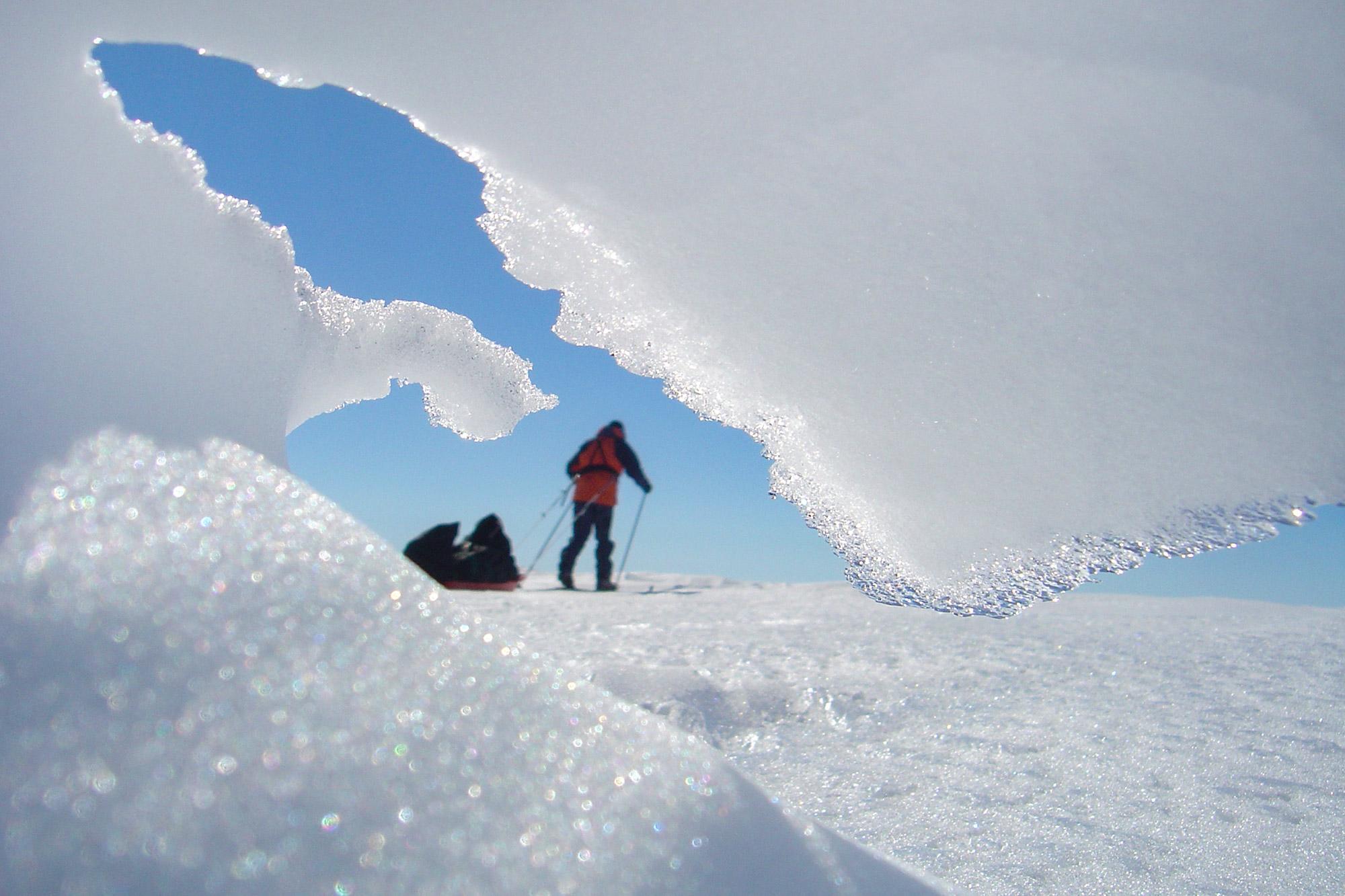 A skier going past a snow formation on the glacier