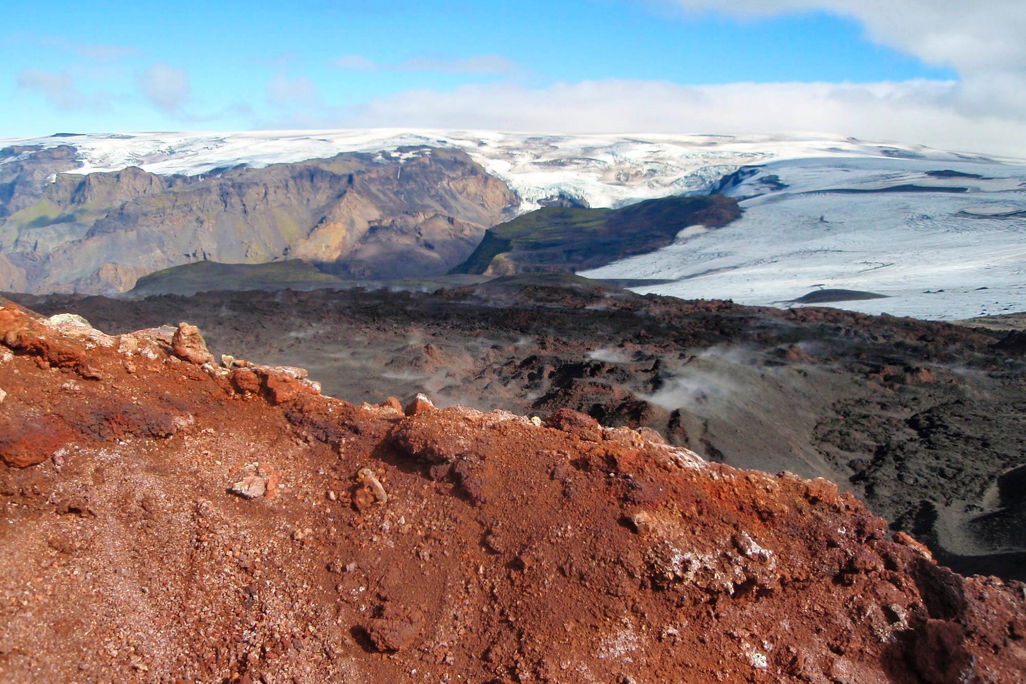 Snowy mountains behind a red mountain in Iceland