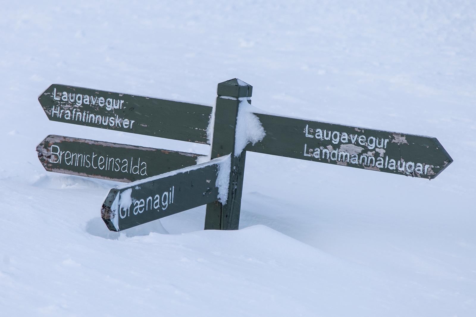 Sign deep in snow pointing towards Laugavegur, Hrafntinnusker, Brennisteinsalda, Grænagil and Landmannalaugar