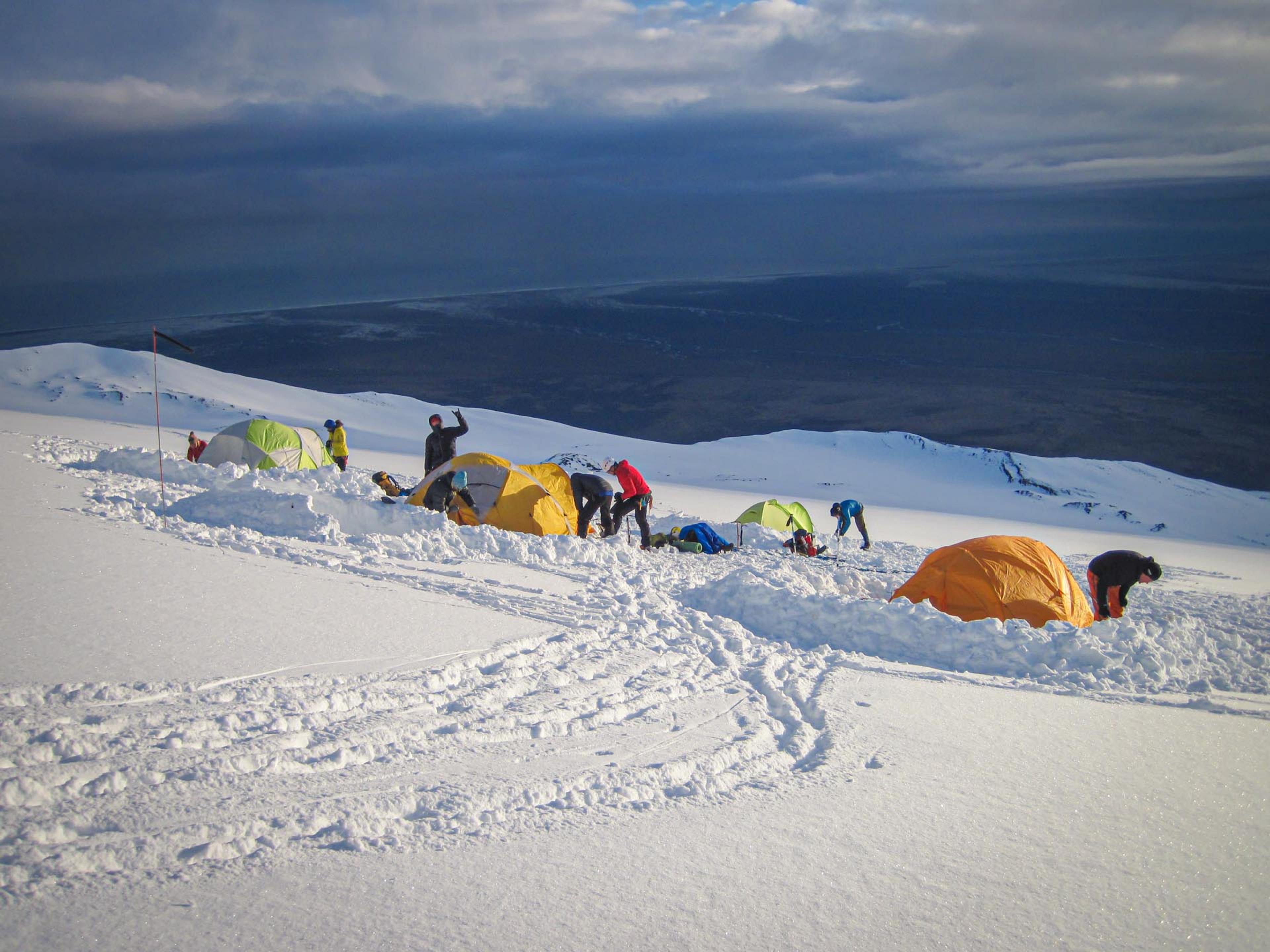 a group with tents in the snow on a mountain in iceland