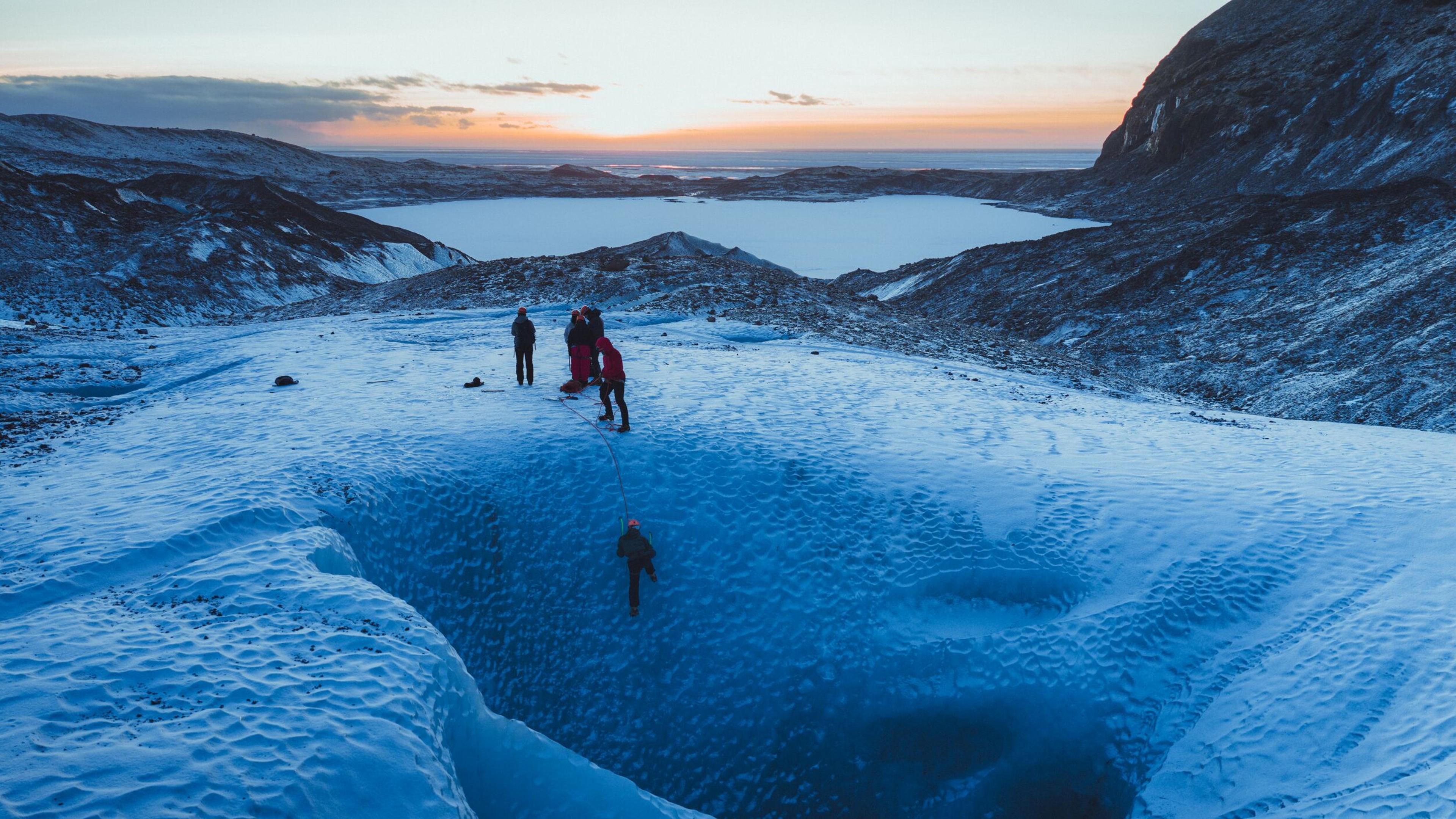 People ice climbing in the sunset