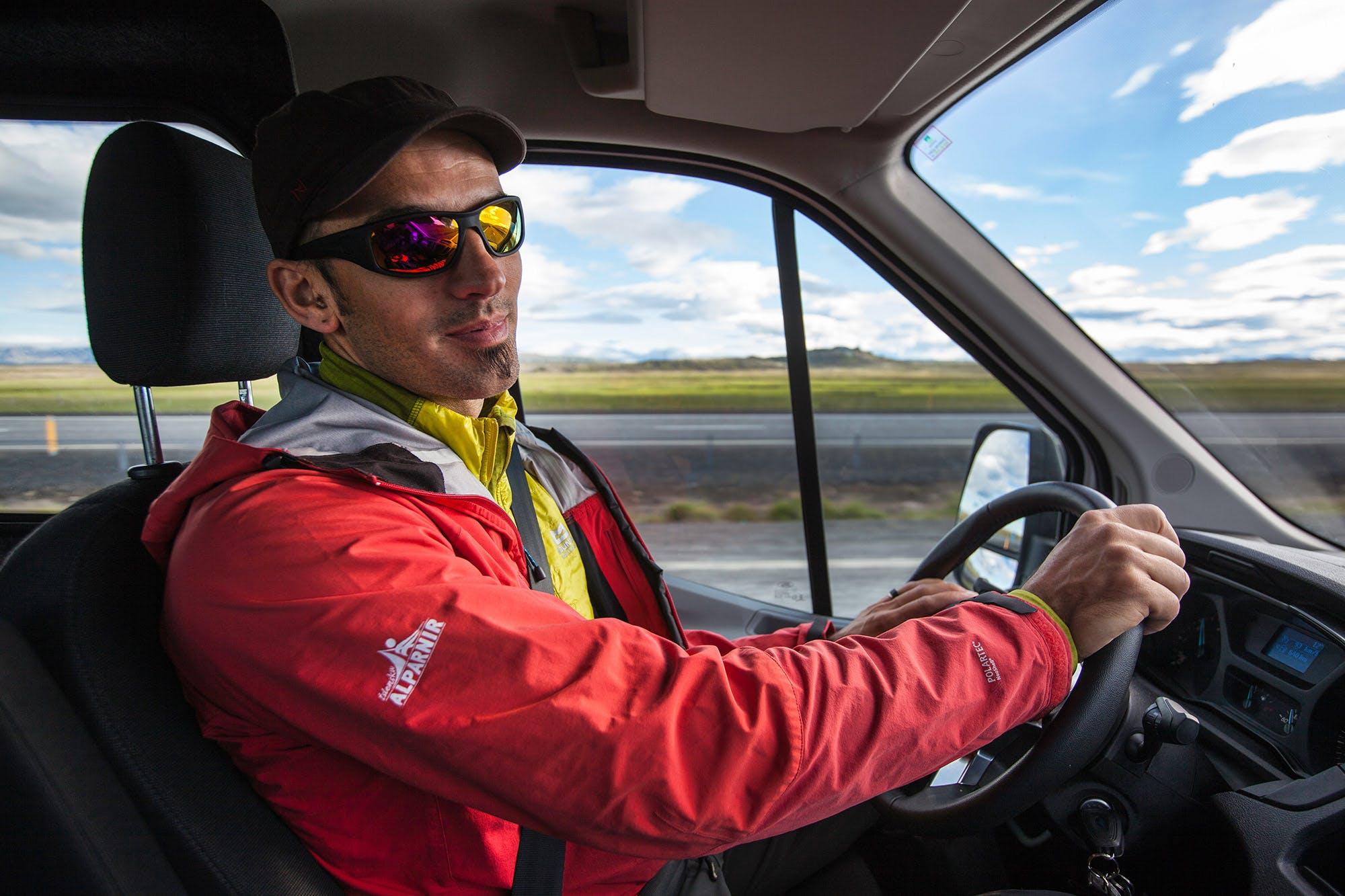 A guide driving a minibus on a day tour with Icelandic Mountain Guides
