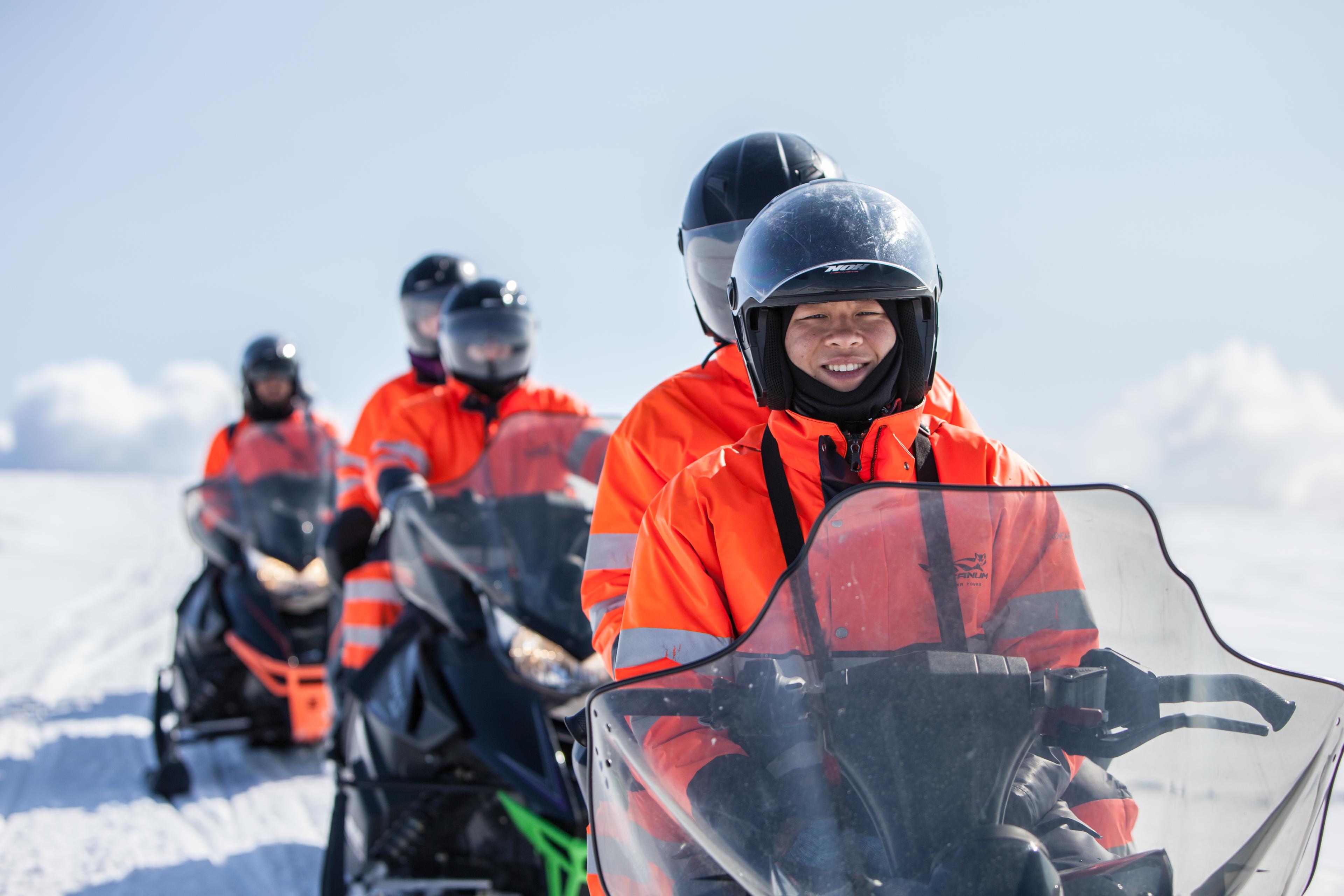 Close up of happy people on a skidoo on the way across the ice cap of Mýrdalsjökull glacier