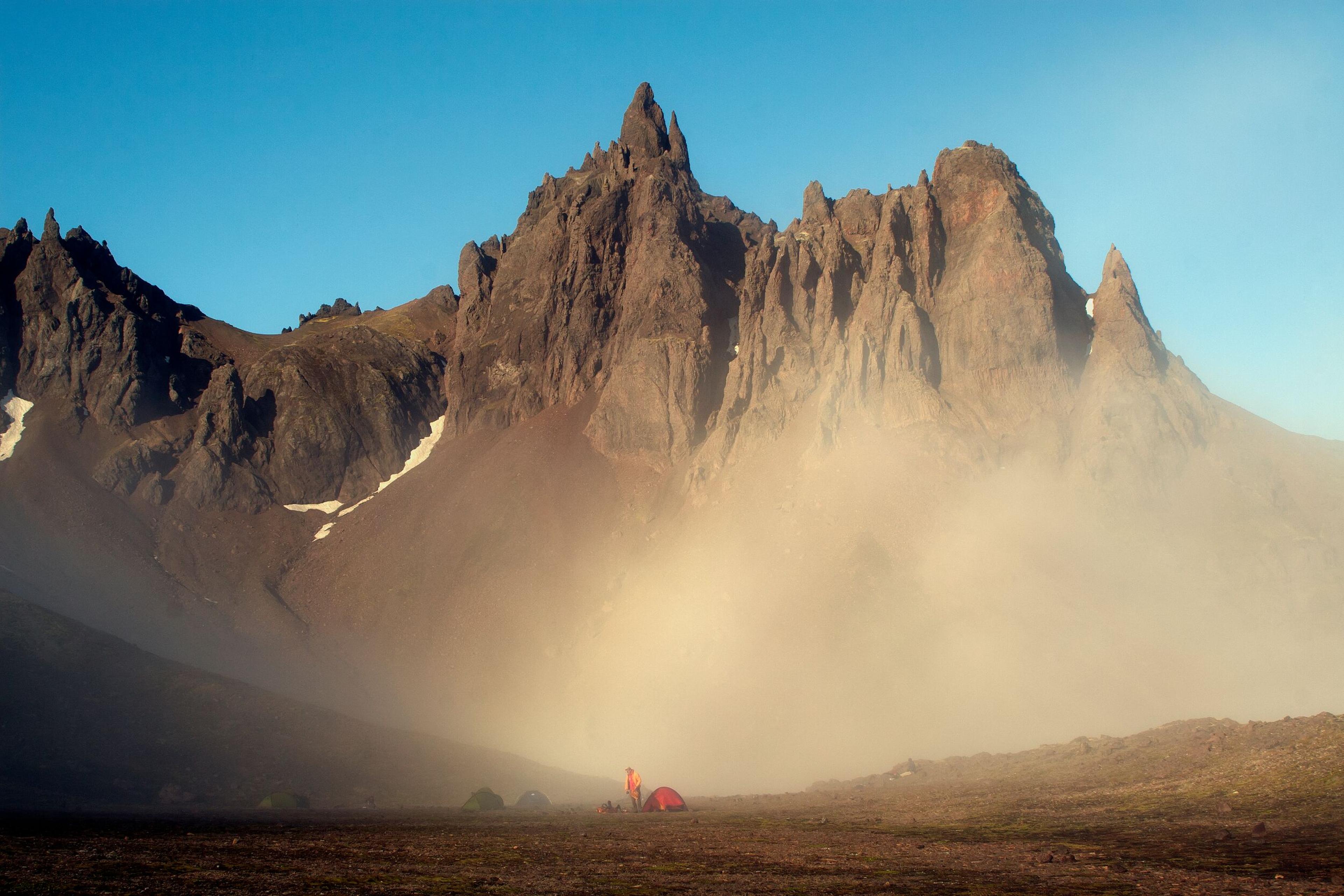 few tents infront of a mountain